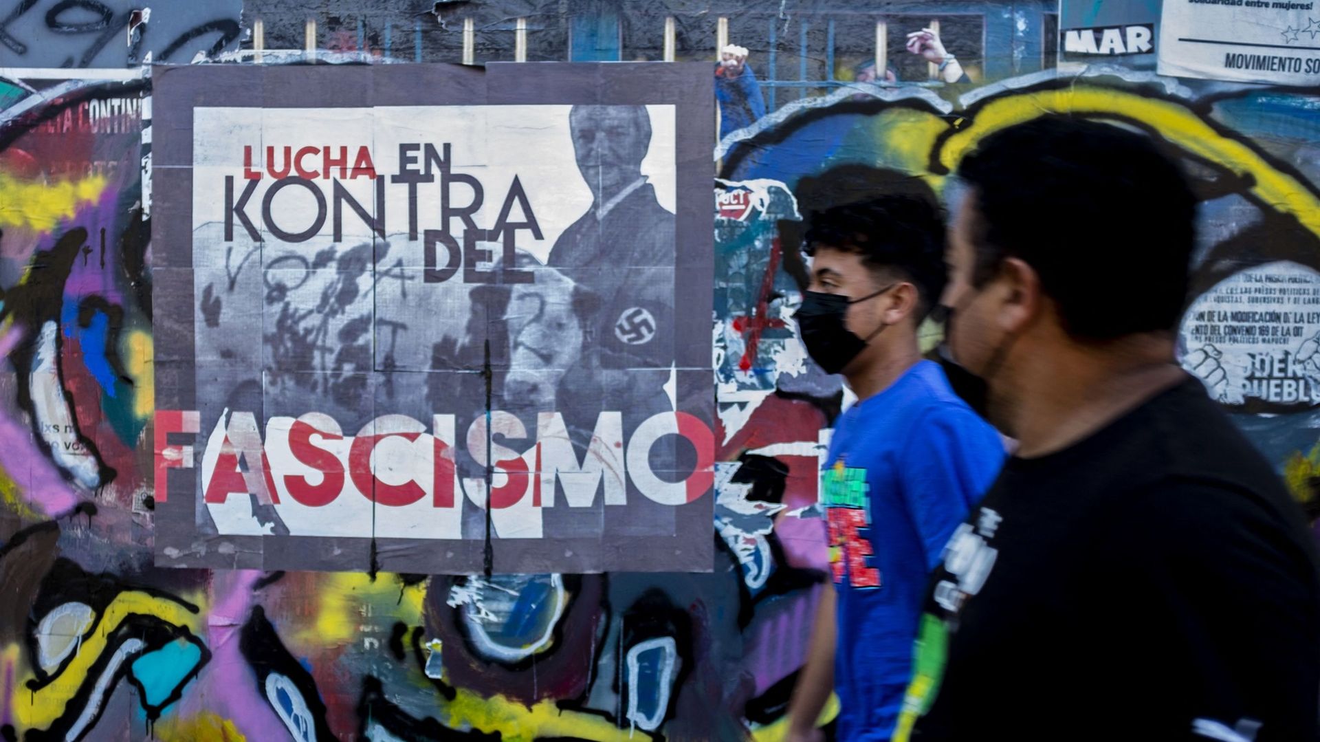 Devant une affiche contre le candidat José Antonio Kast, à Santiago