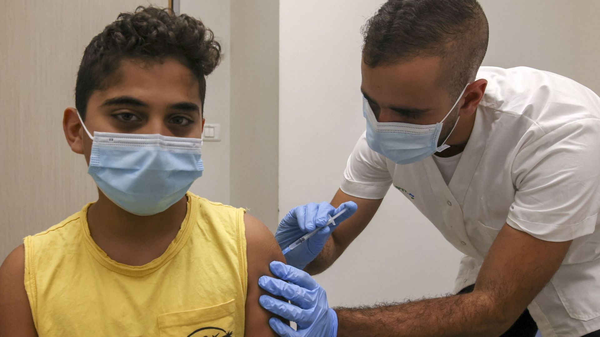 Un soignant injecte une dose de vaccin contre le Covid-19 à un enfant de 12 ans.