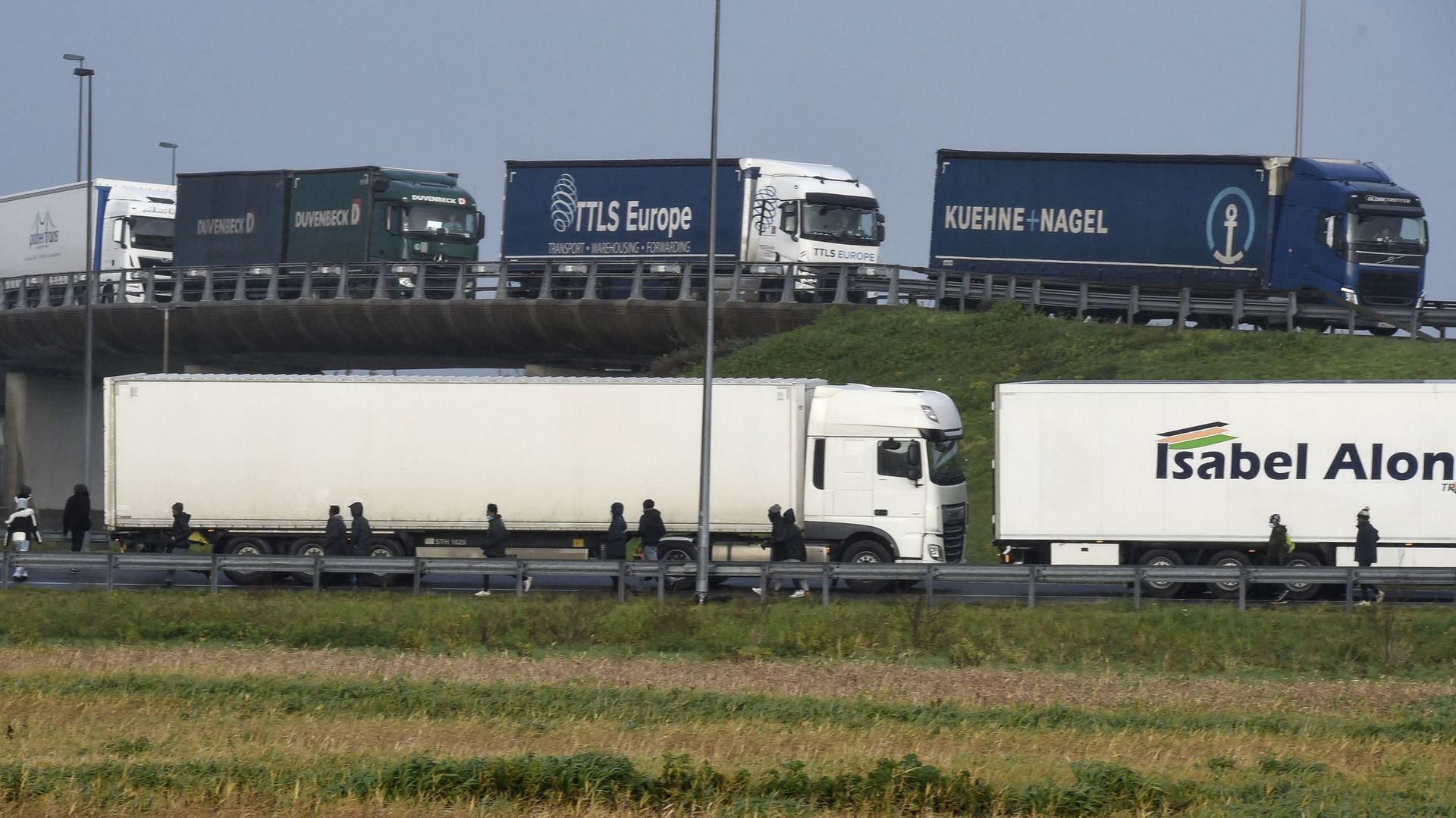 Image d’illustration : Des migrants essaient de monter dans un camion pour tenter d’embarquer sur un ferry pour la Grande-Bretagne, sur l’autoroute A16 près de Calais, dans le nord de la France, le 17 décembre 2020.