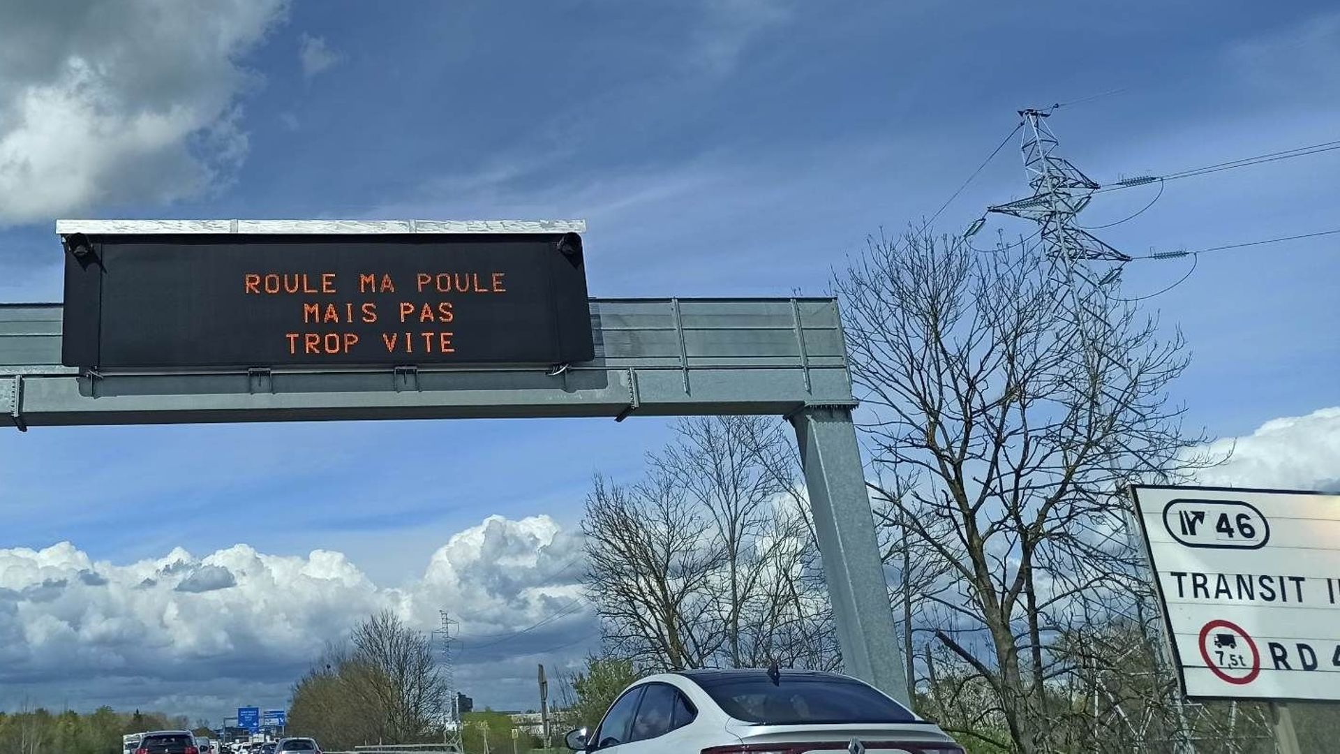 "Roule ma poule mais pas trop vite" affiché sur un panneau rétroéclairé d’autoroute