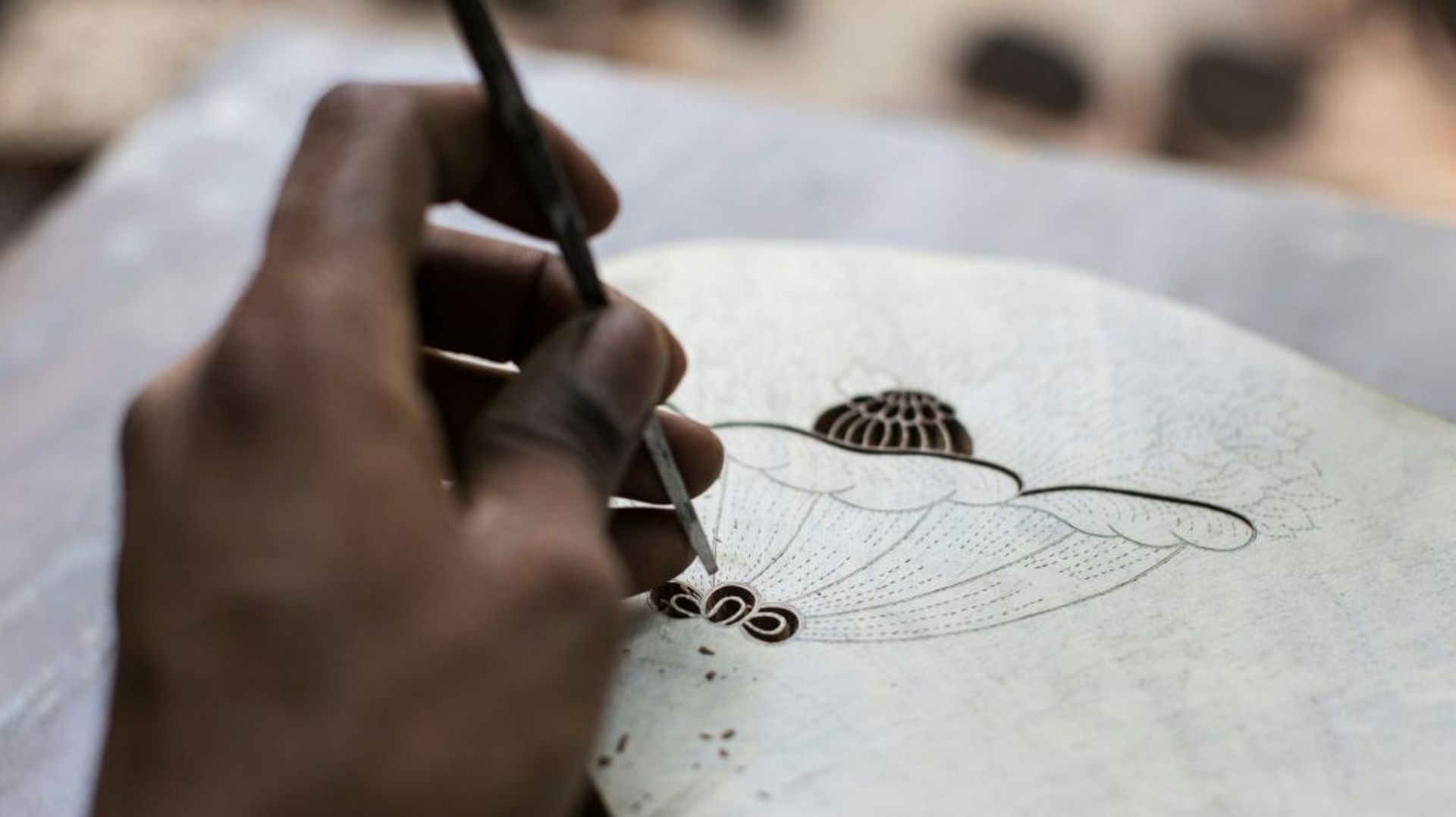 Un employé grave un motif sur une planche à impression dans l'atelier de la créatrice Brigitte Singh, le 2 juin 2022 à Amber, dans l'Etat du Rajasthan, en Inde.