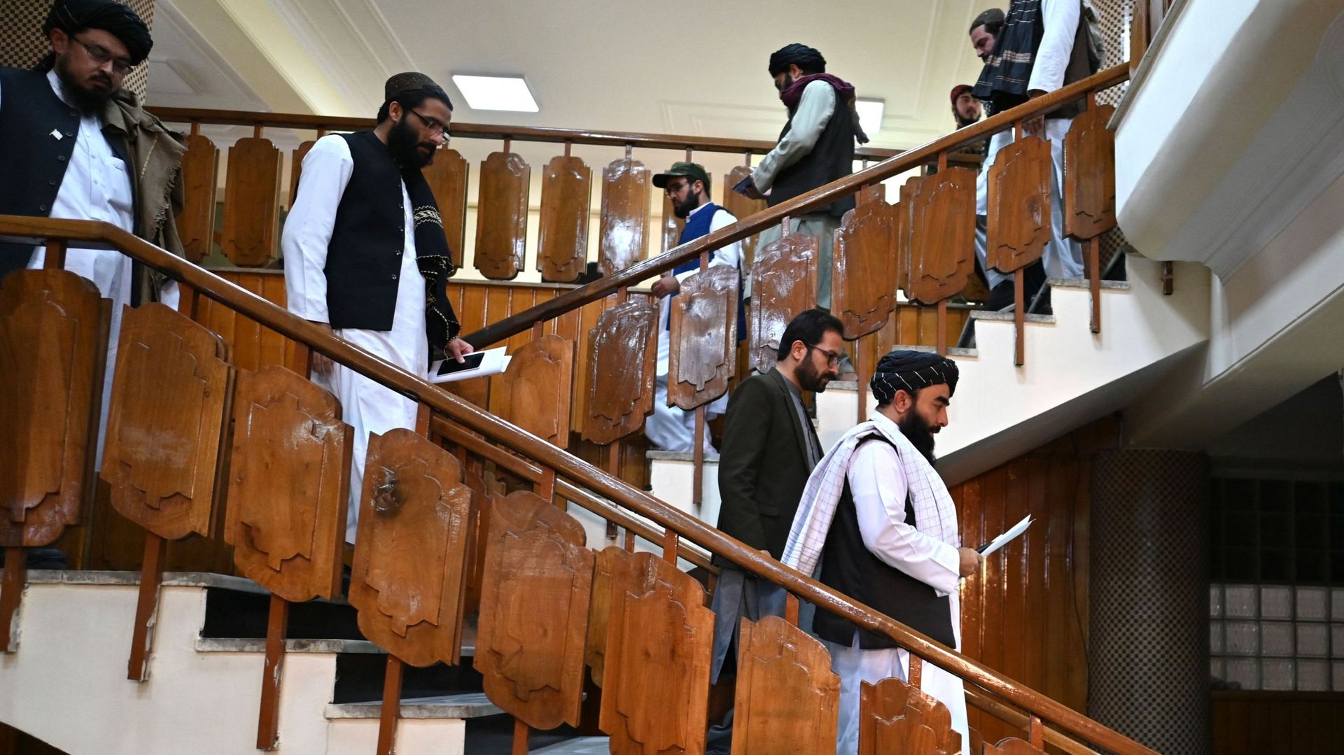 Le porte-parole des talibans, Zabihullah Mujahid (en bas à droite), et le porte-parole des services de renseignement, Khalil Hamraz (à gauche), arrivent pour donner une conférence de presse au centre gouvernemental d'information et de presse à Kaboul.