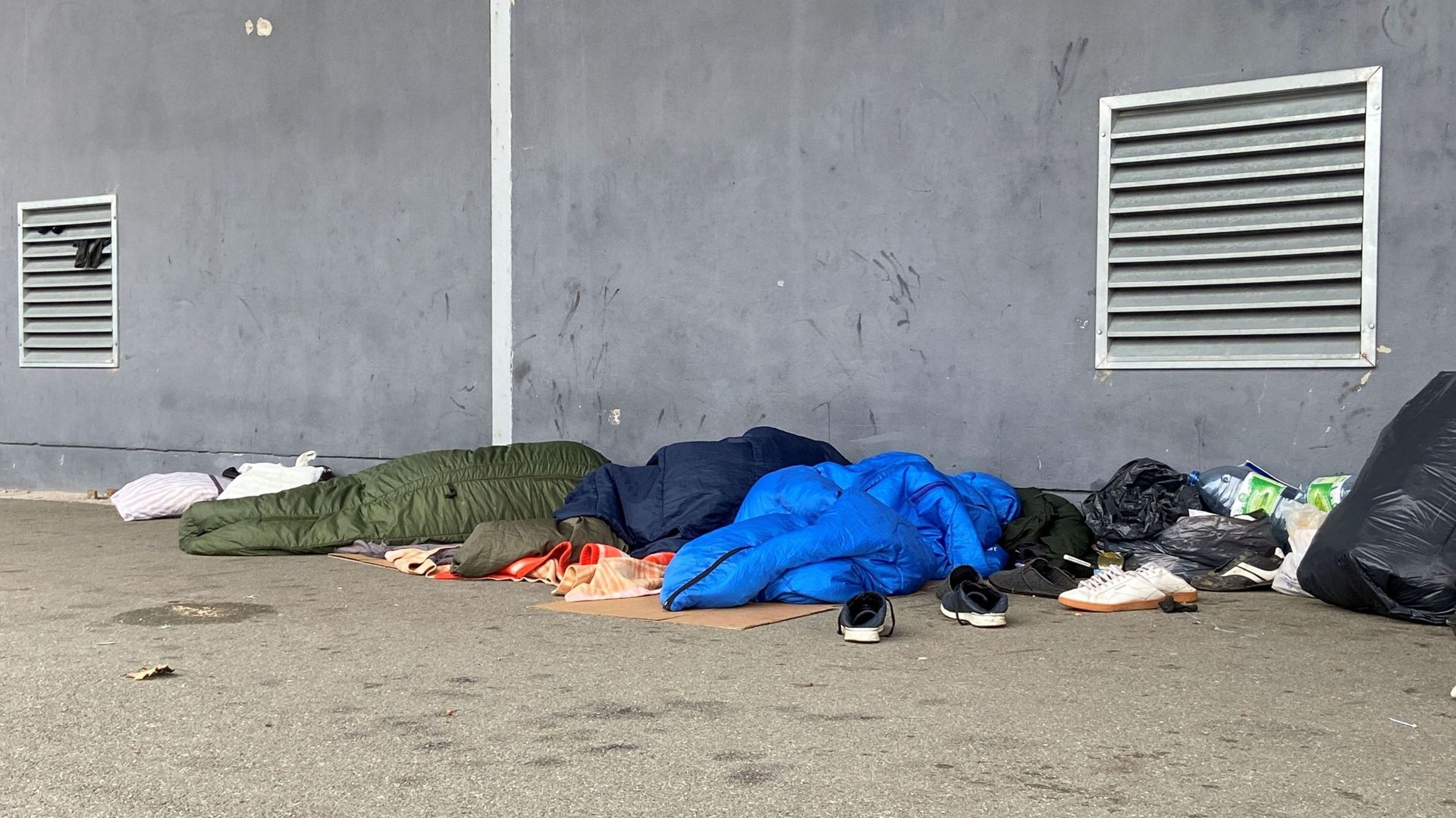 Des migrants dorment près d’un hangar, à Calais.