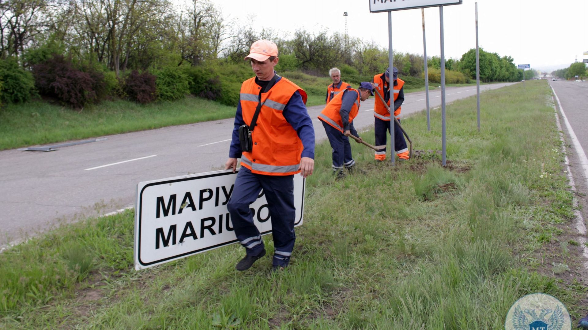 Cette photo prise et publiée par le ministère des transports de la République populaire de Donetsk le 5 mai 2022 montre des travailleurs municipaux qui ont remplacé les panneaux routiers ukrainiens par des panneaux russes à l’extérieur de la ville de Mari