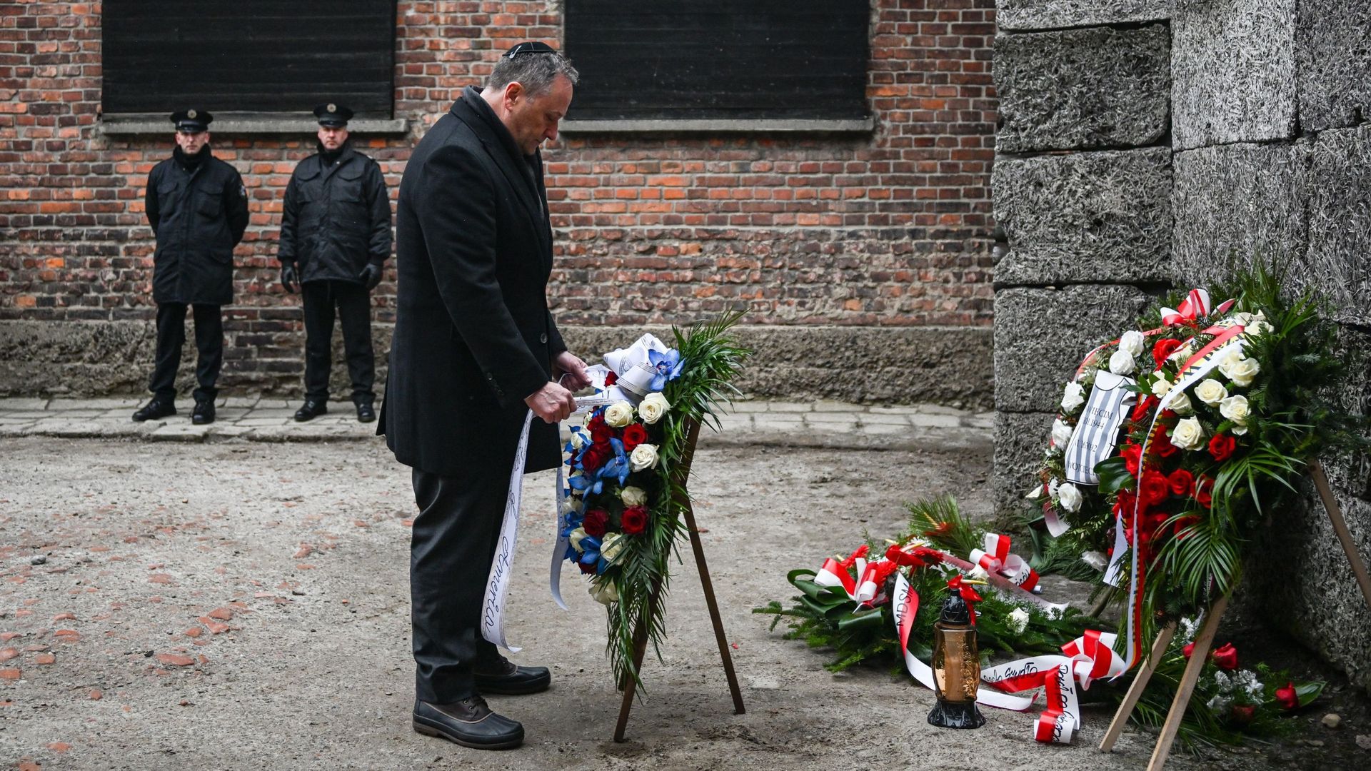 Douglas Emhoff, deuxième gentilhomme des États-Unis, dépose des couronnes en hommage aux victimes du régime nazi près du mur de la mort lors de la journée de commémoration de l’Holocauste sur l’ancien site d’Auschwitz I, le 27 janvier 2023 à Oswiecim, en 