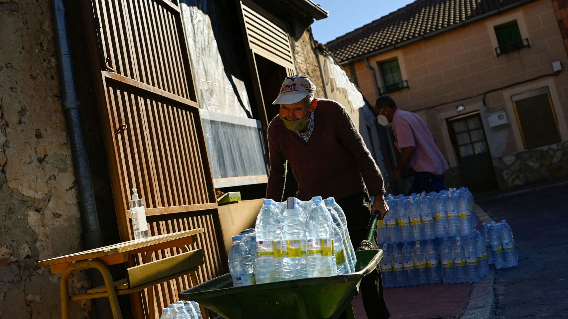 Un homme transporte des bouteilles d’eau minérale dans une brouette à Lastras de Cuellar le 28 juin 2021.
