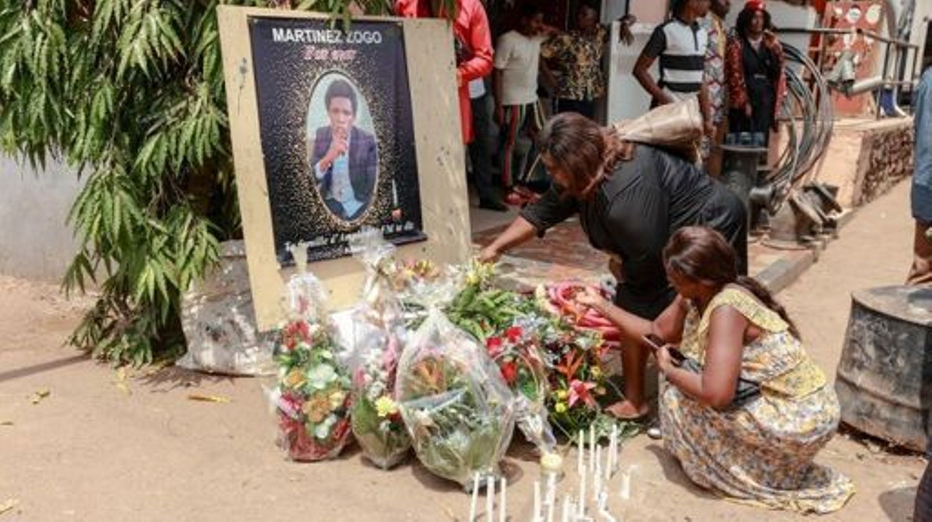 Mourners place a candles and flowers in the courtyard of Radio Amplitude FM, during a tribute ceremony for journalist Martinez Zogo, in the Elig Essono district of Yaounde on January 23, 2023. A popular Cameroon radio journalist who had been missing follo