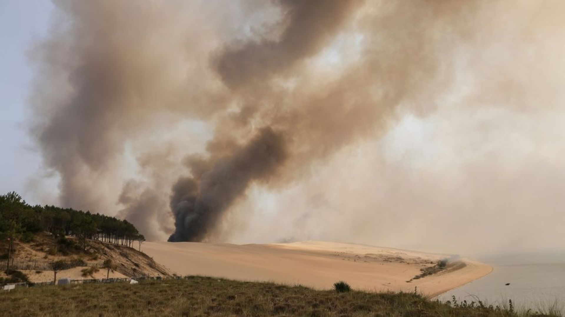 De la fumée s'élève de l'incendie qui ravage la forêt de pins en contrebas de la dune du Pyla, en Gironde, le 18 juillet 2022