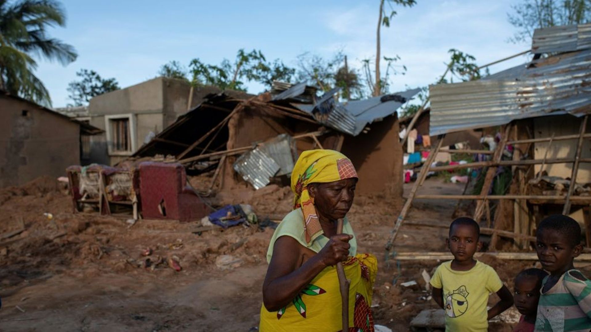 Une famille devant des maisons détruites par le cyclone Gombe à Nampula, le 13 mars 2022