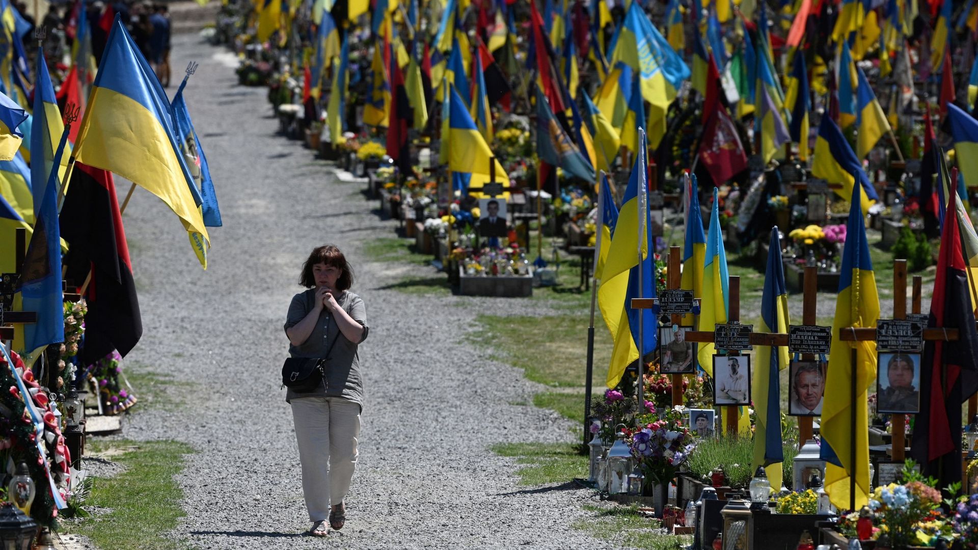 Une femme marche parmi les tombes du cimetière militaire de Lychakiv, dans la ville de Lviv, à l'ouest de l'Ukraine, le 1er juin 2023.