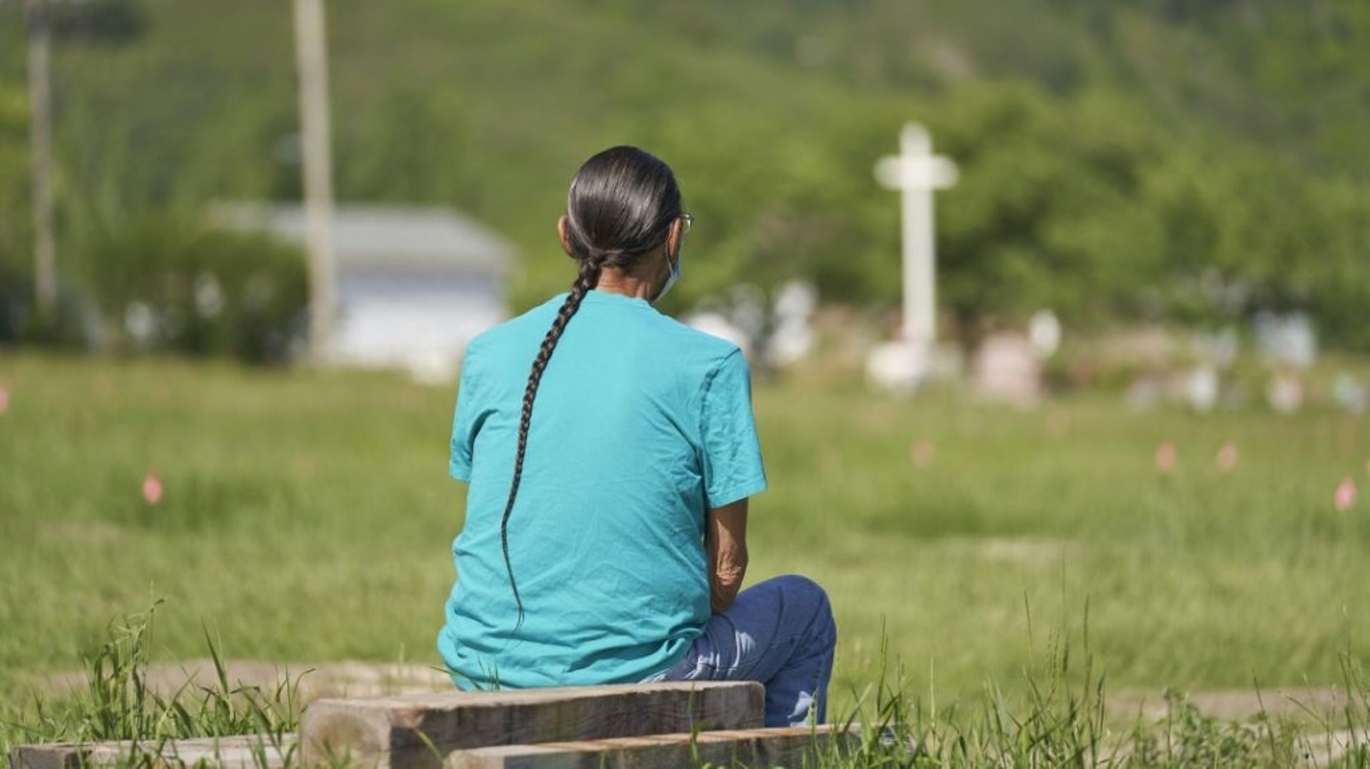 Un homme se recueille devant l’emplacement où ont été découvertes plus de 750 tombes anonymes sur le site d’un ancien pensionnat pour autochtones de Marieval dans l’Ouest canadien, photographié le 25 juin 2021