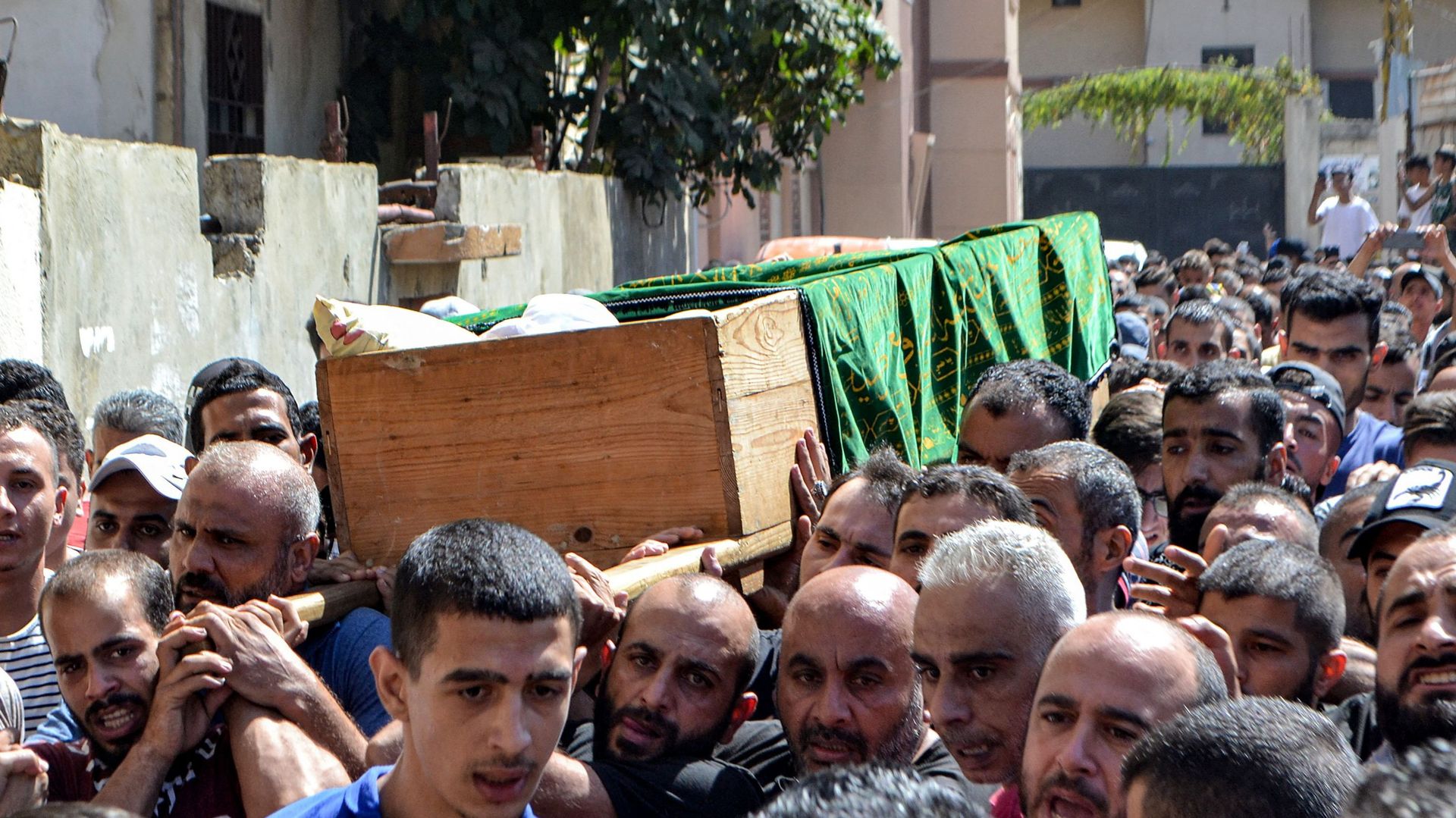 Des personnes en deuil marchent avec le corps de l’une des victimes du naufrage au large des côtes syriennes, à Tripoli, au nord du Liban, le 24 septembre 2022.