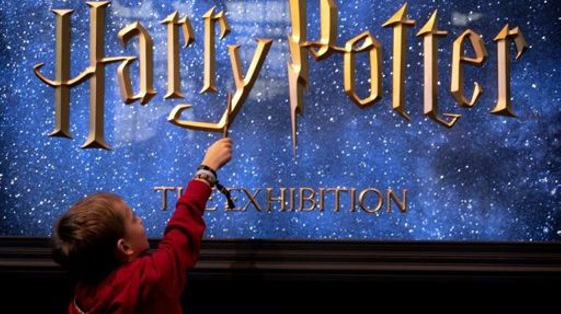 A young visitor holds a magic wand during the opening of the European exhibition of Harry Potter in Vienna, Austria on December 16, 2022.   Andrea KLAMAR-HUTKOVA / AFP