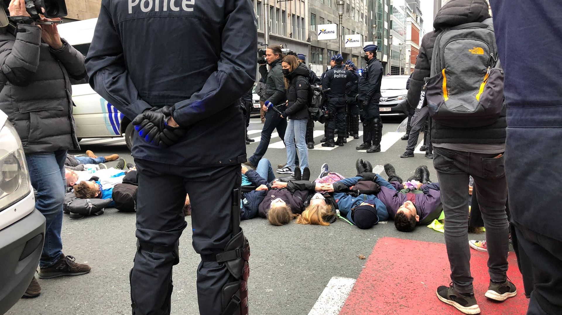Des militants d’Extinction Rebellion bloquent la rue de la Loi à Bruxelles en s’allongeant par terre.