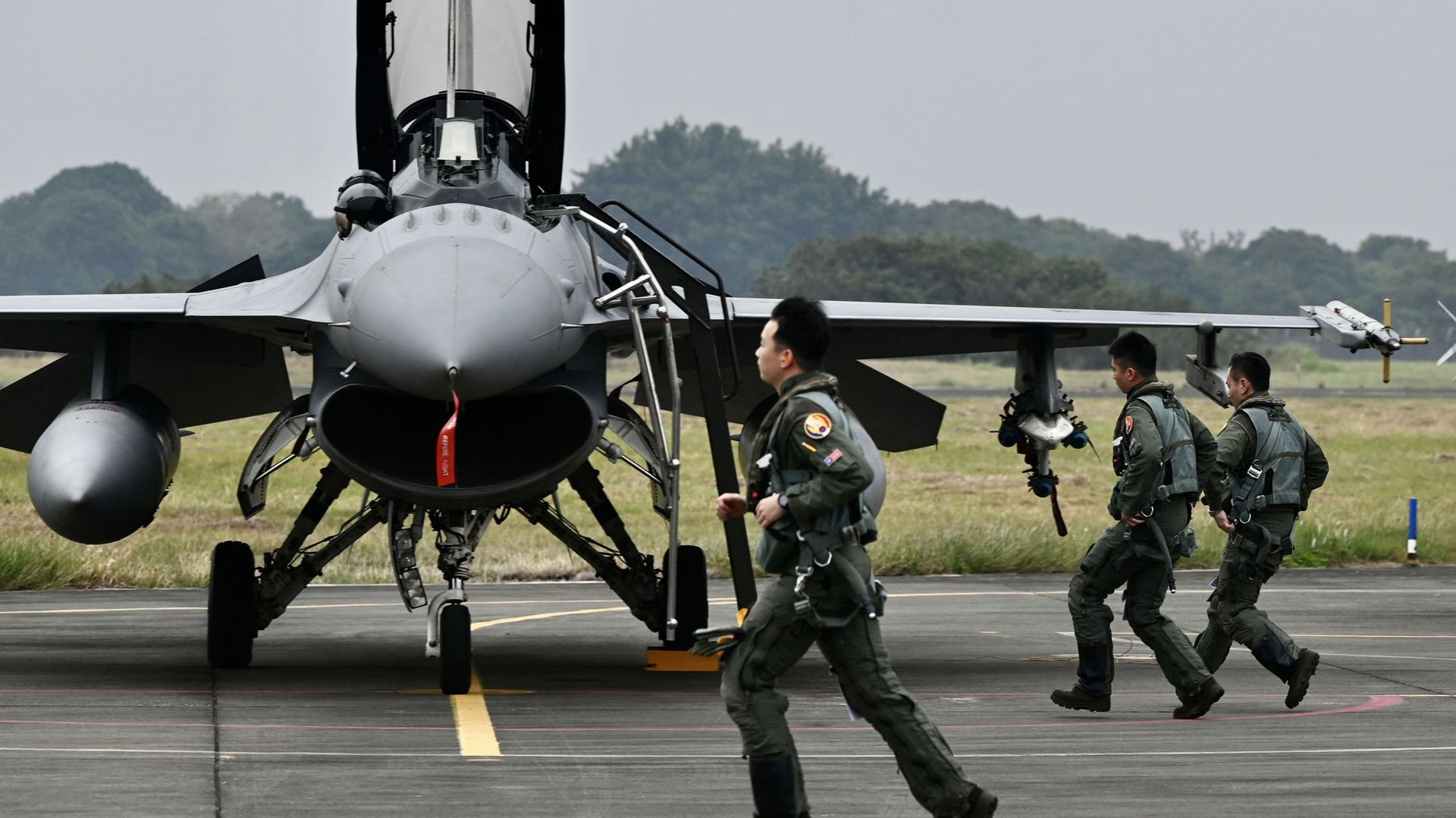 Des pilotes de l'armée de l'air taïwanaise passent devant un chasseur F-16V armé de fabrication américaine sur une base aérienne à Chiayi, dans le sud de Taïwan, le 5 janvier 2022.