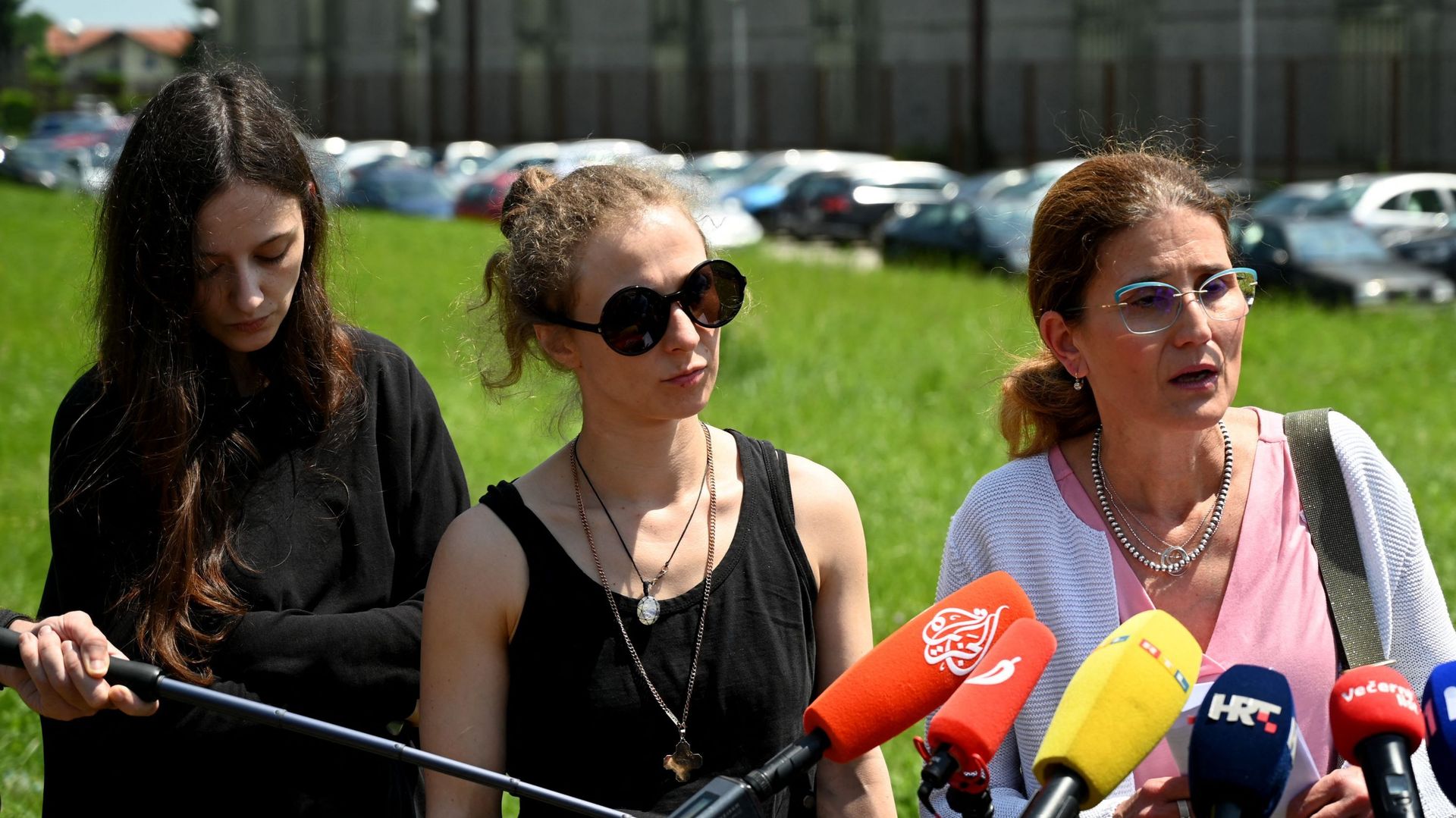 Les activistes russes et membres des Pussy Riot Maria Alikhina (au centre) et Lucy Stein des Pussy Riot (gauche) écoutent l’avocate Lina Budak durant une conférence de presse devant la prison de Zagreb.