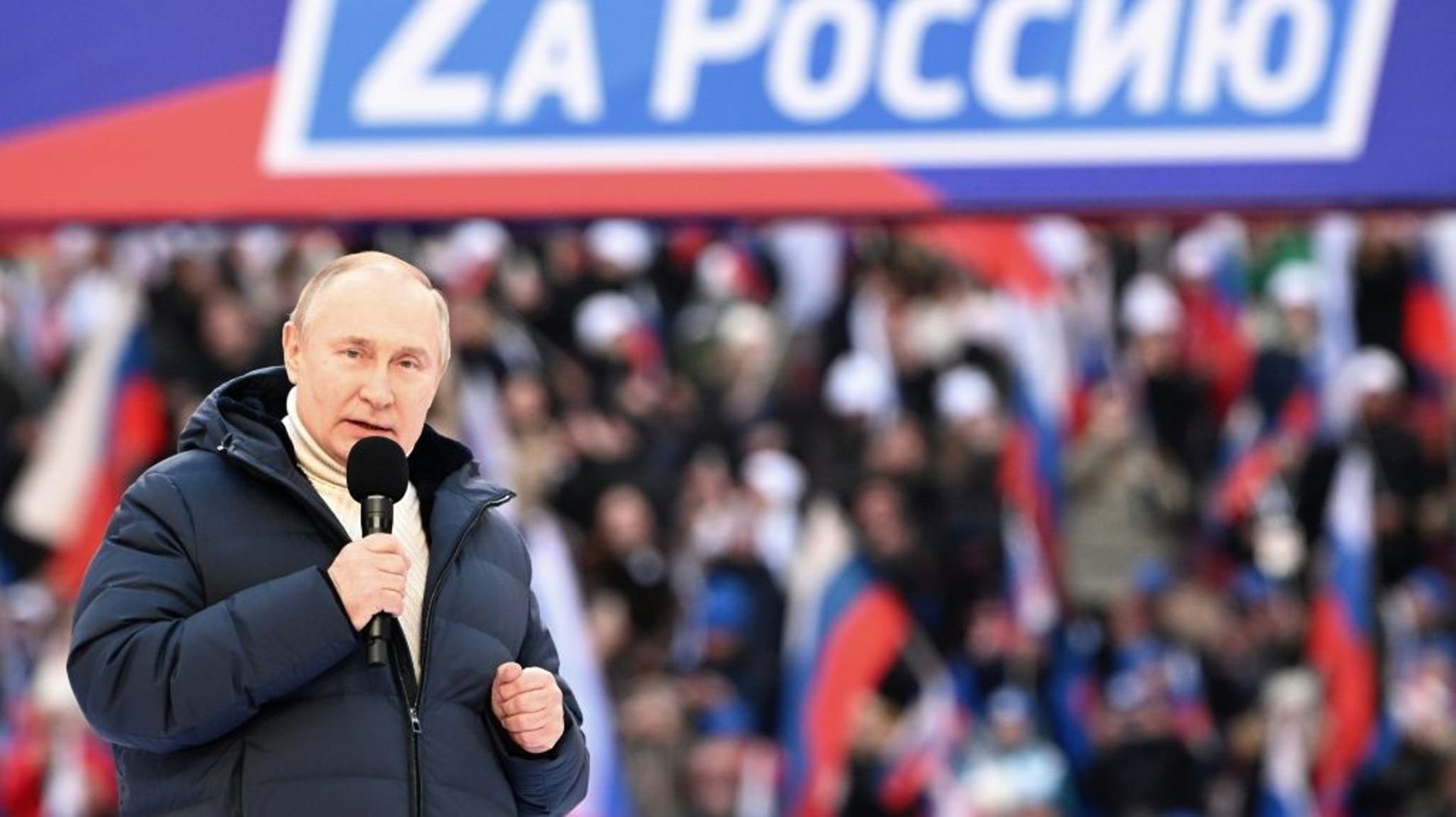 Le président russe Vladimir Poutine au stade Luzhniki de Moscou le 18 mars 2022. La banderole indique "Pour la Russie"