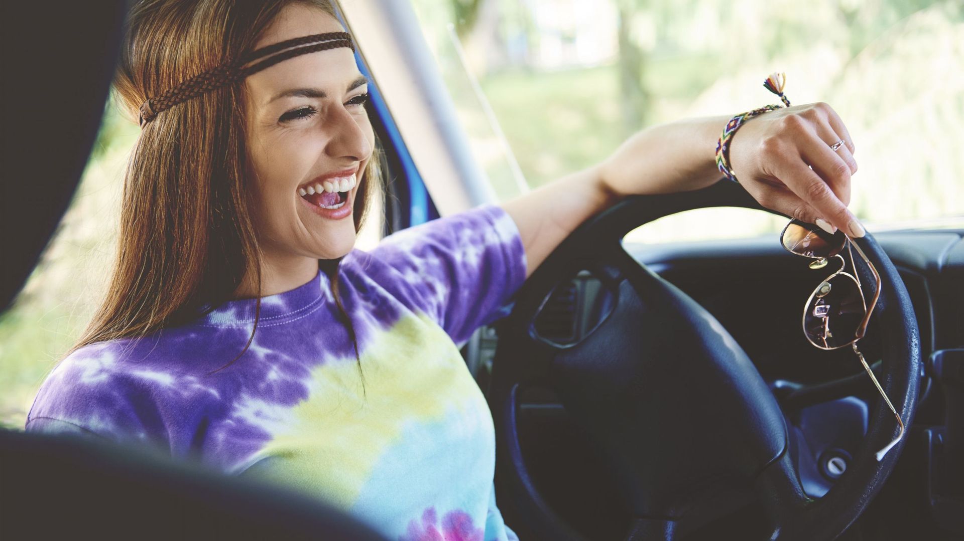 Young boho woman laughing in front seat of recreational van