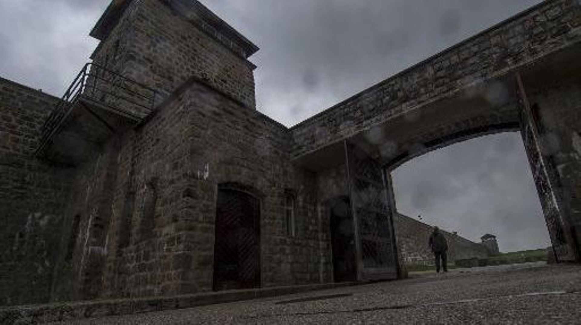 Un homme passe sous le portail de l'ancien camp de concentration nazi de Mauthausen, dans le nord de l'Autriche, le 28 avril 2015