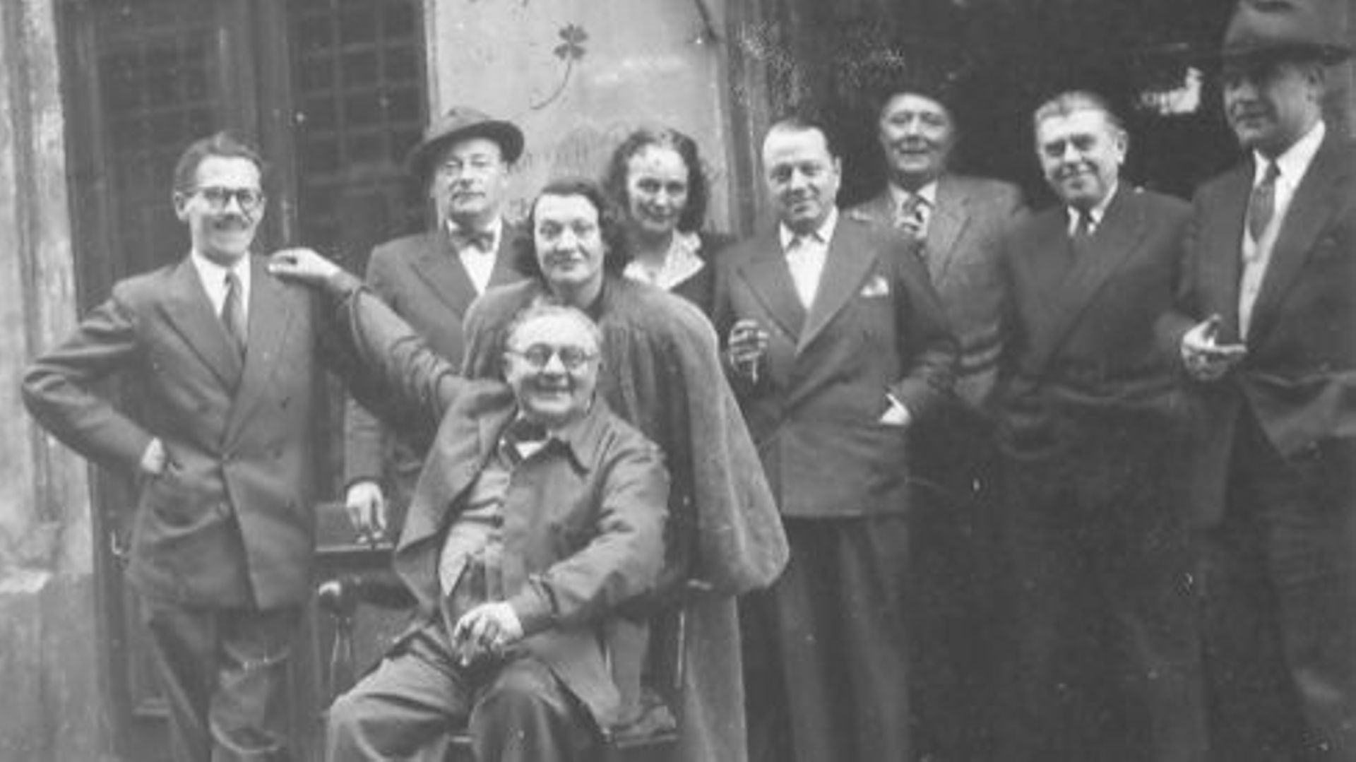 De gauche à droite : Marcel Mariën, Camille Goemans, Gérard Van Bruaene (assis), Irène Hamoir, Georgette Magritte, E.L.T. Mesens, Louis Scutenaire, René Magritte, Paul Colinet, à La Fleur en Papier Doré à Bruxelles
