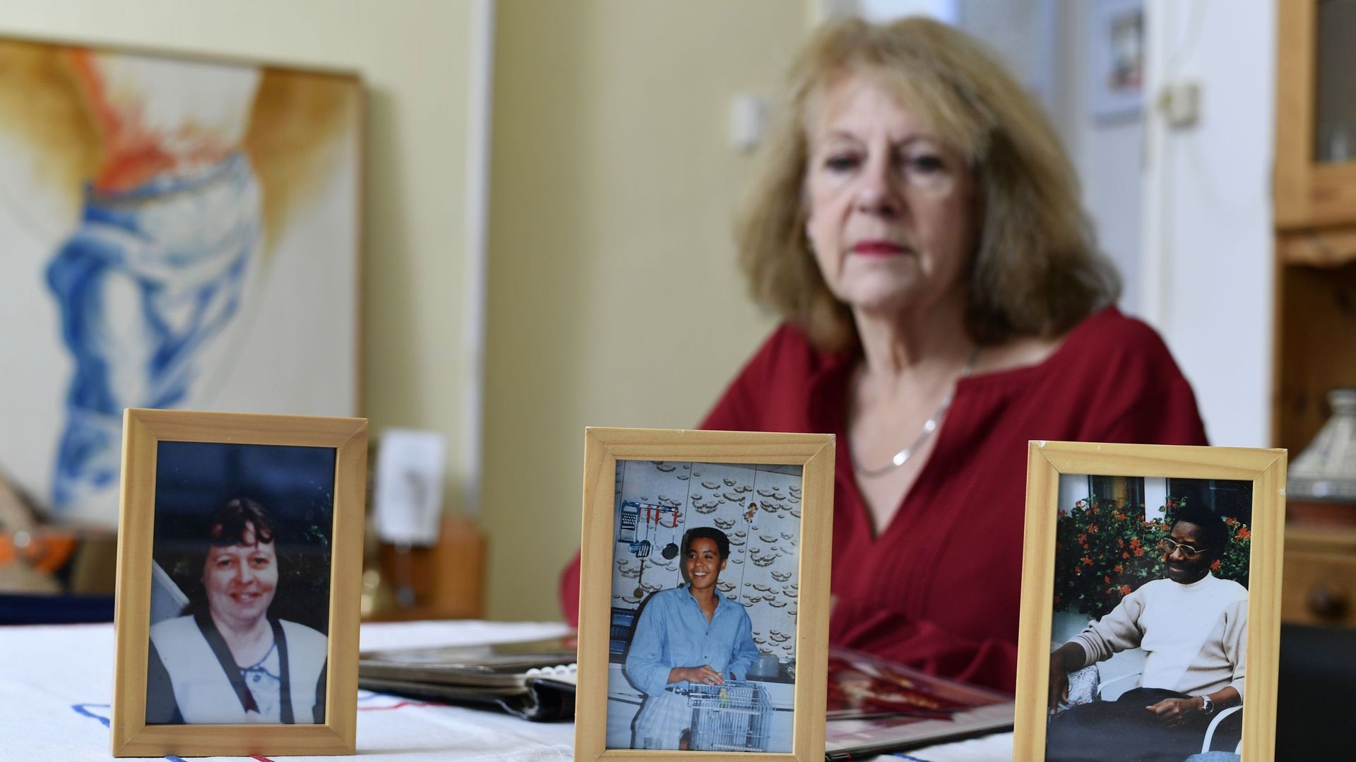 Martine Beckers, qui a perdu sa soeur, son beau-frère et sa nièce durant le génocide au Rwanda, pose derrière les photos des disparus