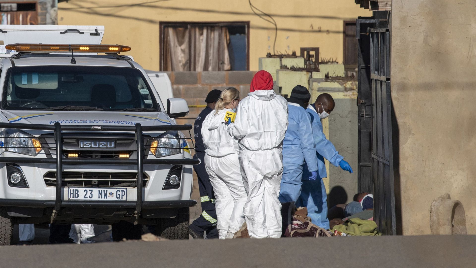 Des membres de la police sud-africaine (SAPS) et du service de médecine légale inspectent la scène d'une fusillade de masse à Soweto, en Afrique du Sud, le 10 juillet 2022.