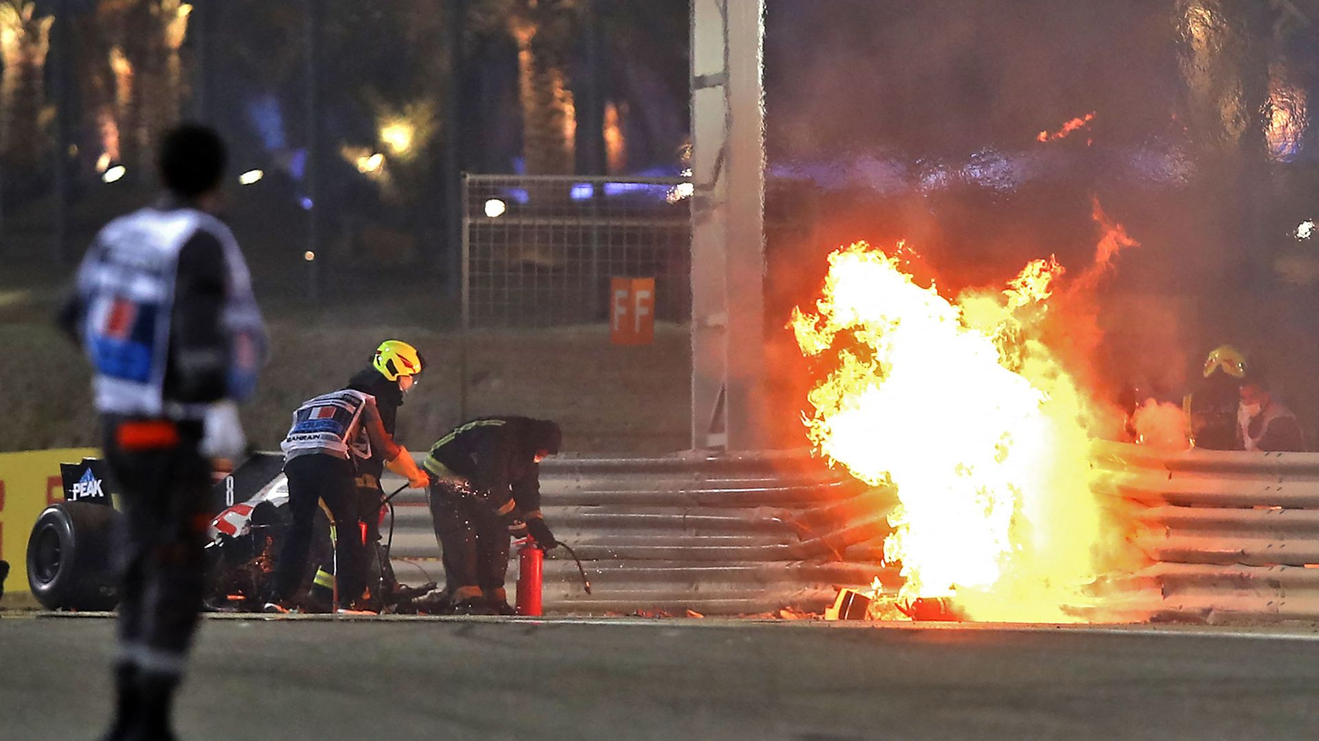 Les secours tentent d’éteindre le feu provoqué par la Haas de Romain Grosjean.