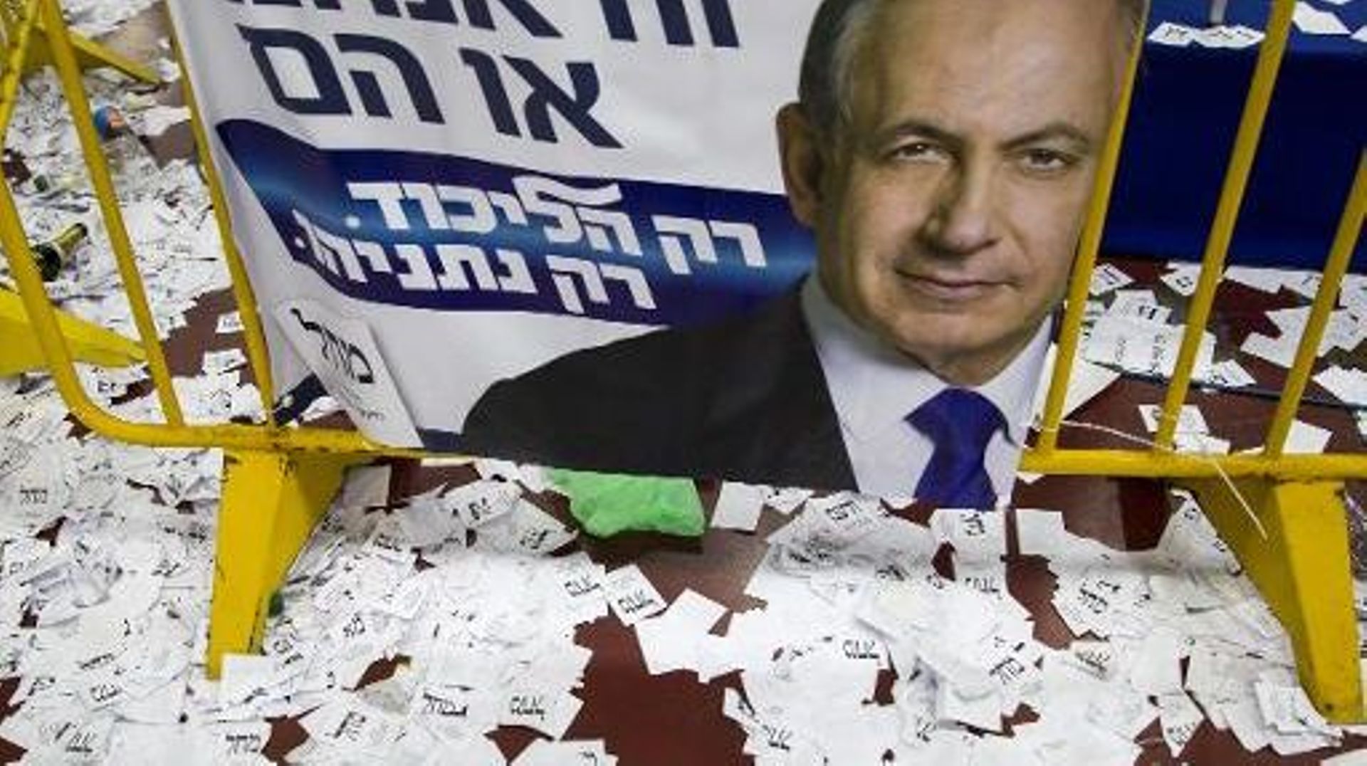 Des bulletins de vote autour d'une affiche de campagne du Premier ministre sortant et candidat du Likoud aux législatives israéliennes Benjamin Netanyahu, le 18 mars 2015 à Tel-Aviv