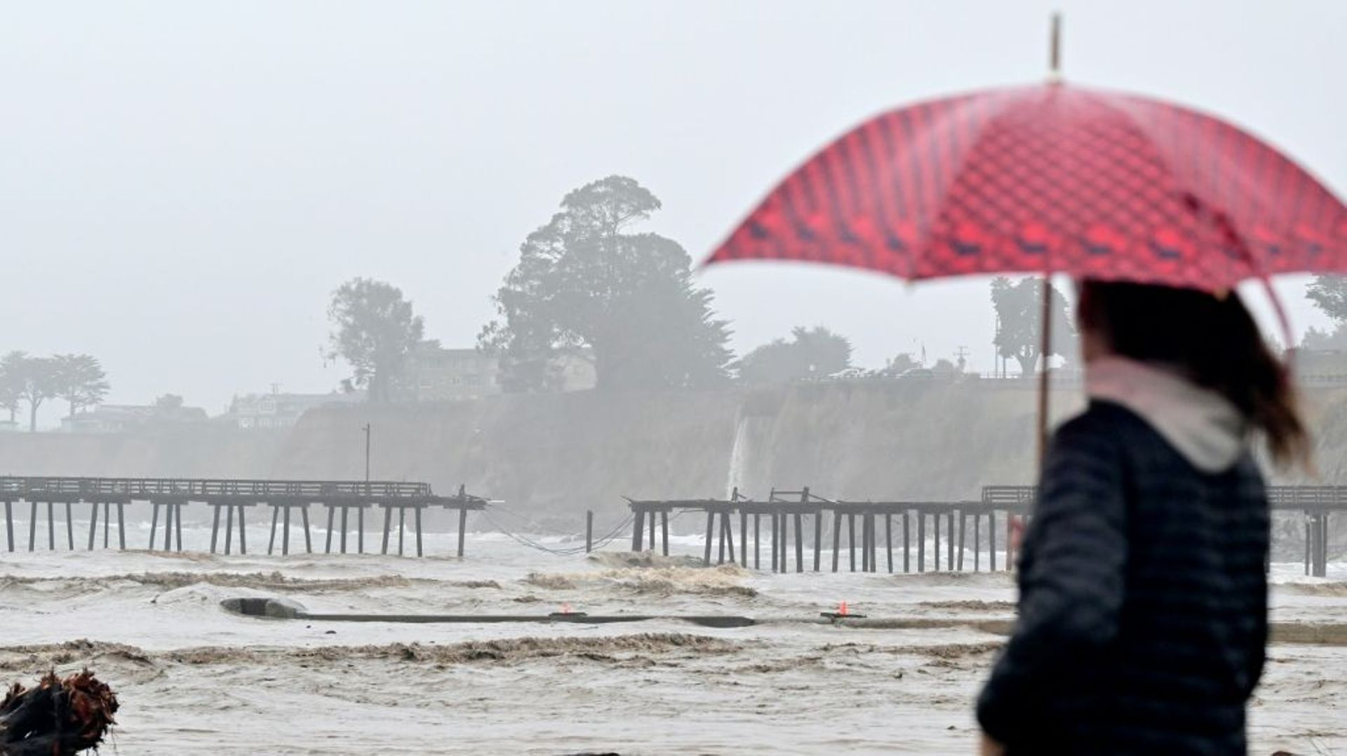 Une passante contemple la jetée détruite de Capitola, depuis la ville voisine d'Aptos, près de San Francisco en Californie, le 9 janvier 2023