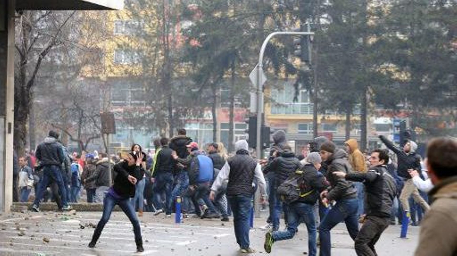 Des manifestants lancent des pierres sur des policiers lors d'une manifestation contre la dégradation de l'économie bosniaque, le 6 février 2014 à Tuzla (nord) 