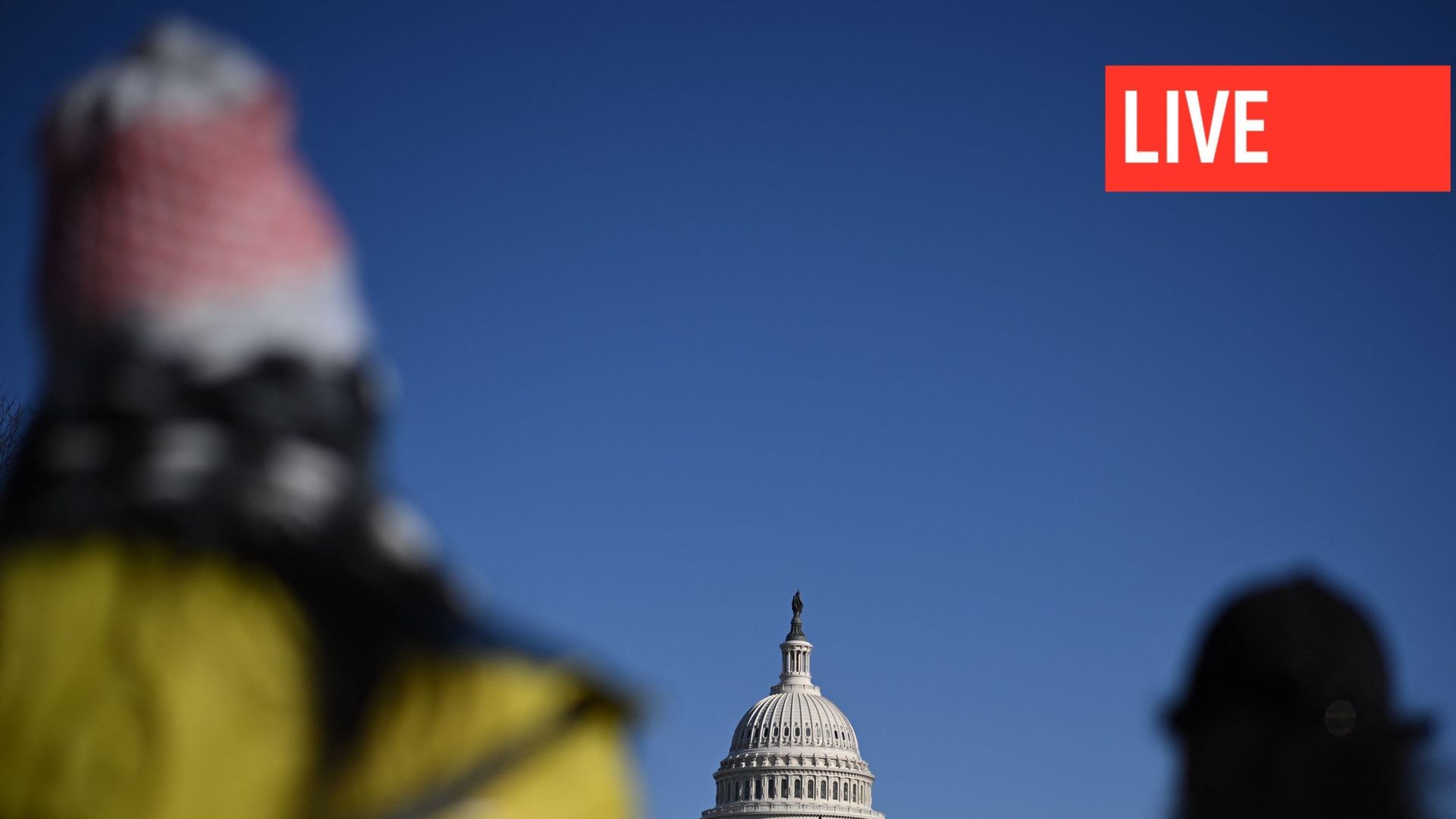 Des piétons attendent de traverser une rue près du Capitole américain à Washington, DC, le 23 décembre 2022. Le Congrès américain a approuvé le 23 décembre un vaste programme de dépenses annuelles qui comprend 45 milliards de dollars d'aide à l'Ukraine et