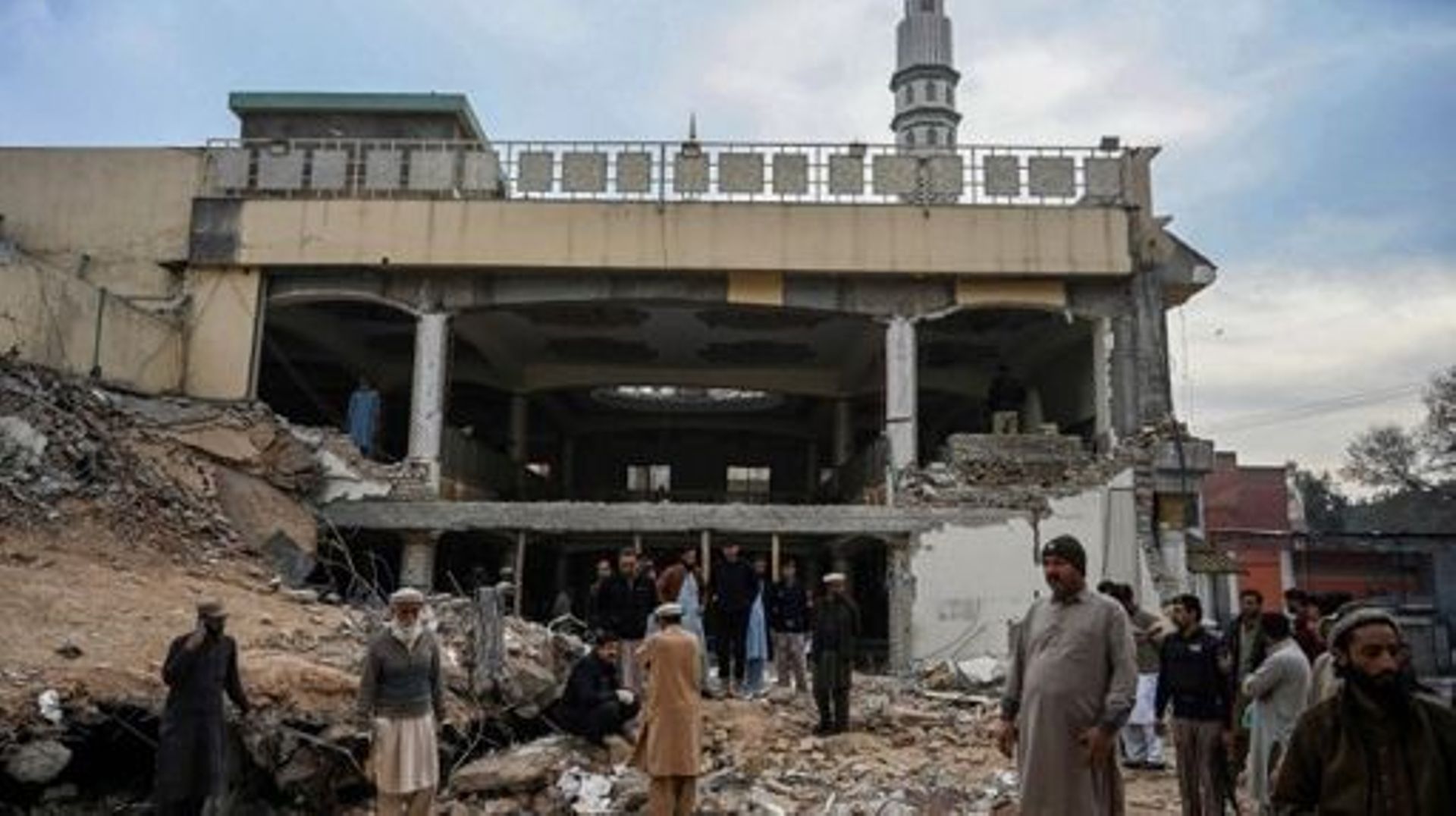 Des policiers en civil inspectent le site alors qu'ils se rassemblent au-dessus des décombres d'une mosquée endommagée suite à l'attentat suicide du 30 janvier à l'intérieur du quartier général de la police à Peshawar, le 1er février 2023.  Une explosion 