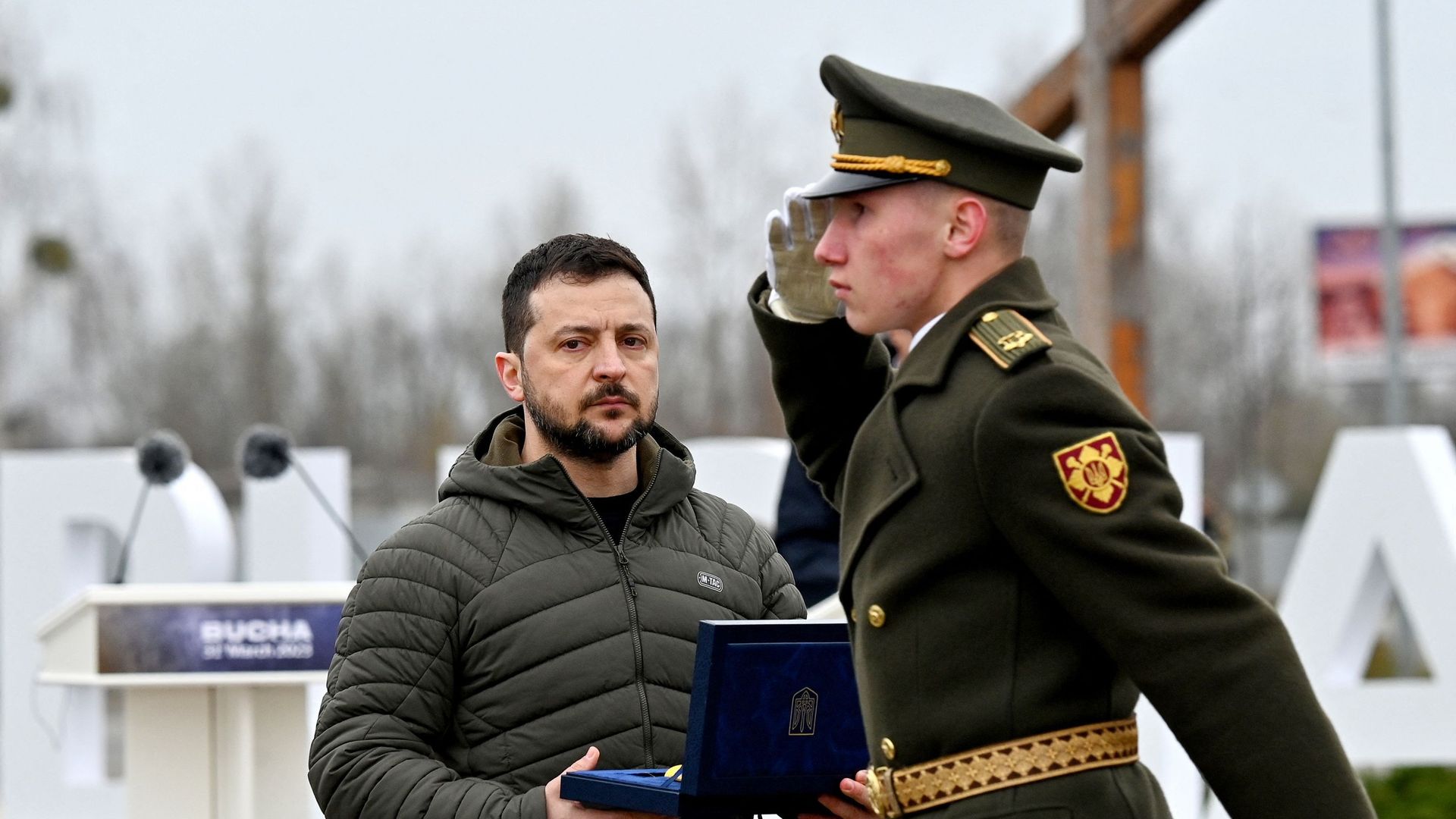 Le président ukrainien Volodymyr Zelensky tient une récompense lors d'une cérémonie marquant le premier anniversaire du retrait des troupes russes de la ville ukrainienne de Boutcha, le 31 mars 2023.
