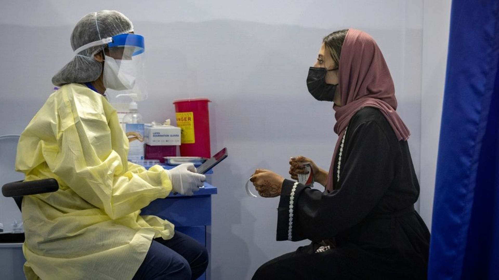 Un infirmier scanne un code avant d'administrer un vaccin contre le Covid-19 à une femme le 9 août 221 à  Errahma, près de Casablanca