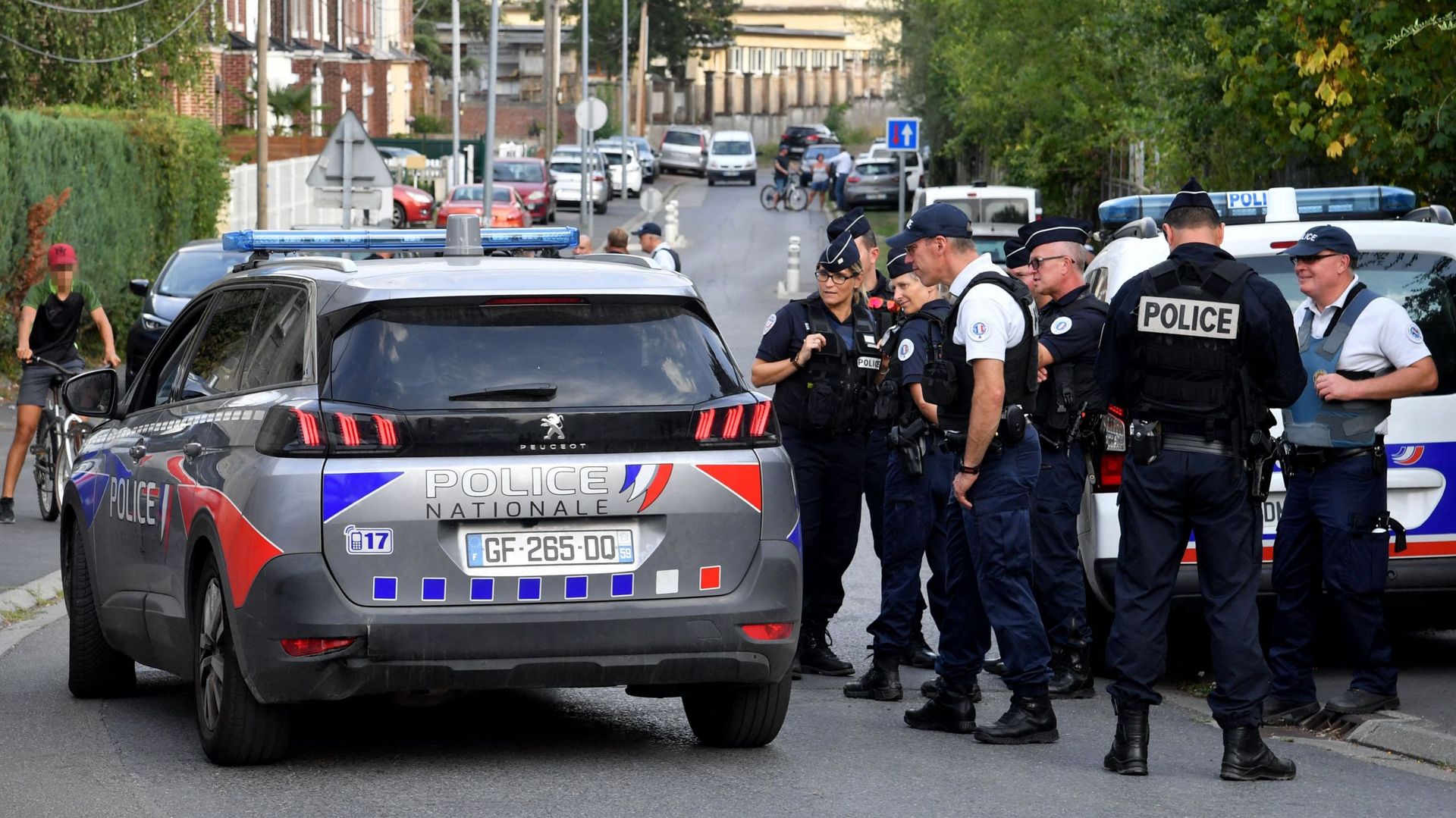 Des policiers se tiennent dans une rue où se trouve une maison appartenant à la famille d'Iman Hassan Iquioussen, à Lourches, dans le nord de la France, le 30 août 2022.