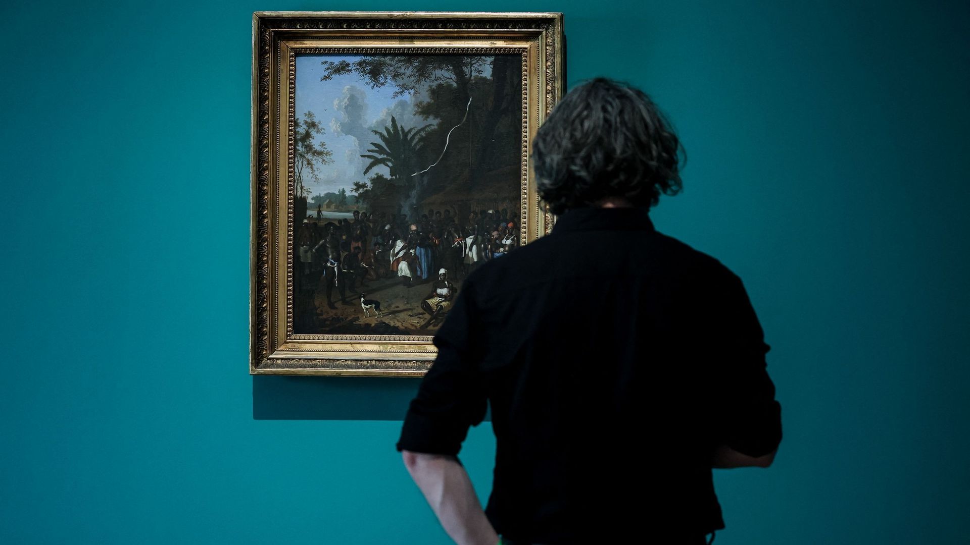 Visiteur face à un tableau de l’exposition "Slavery" du Rijksmuseum d’Amsterdam