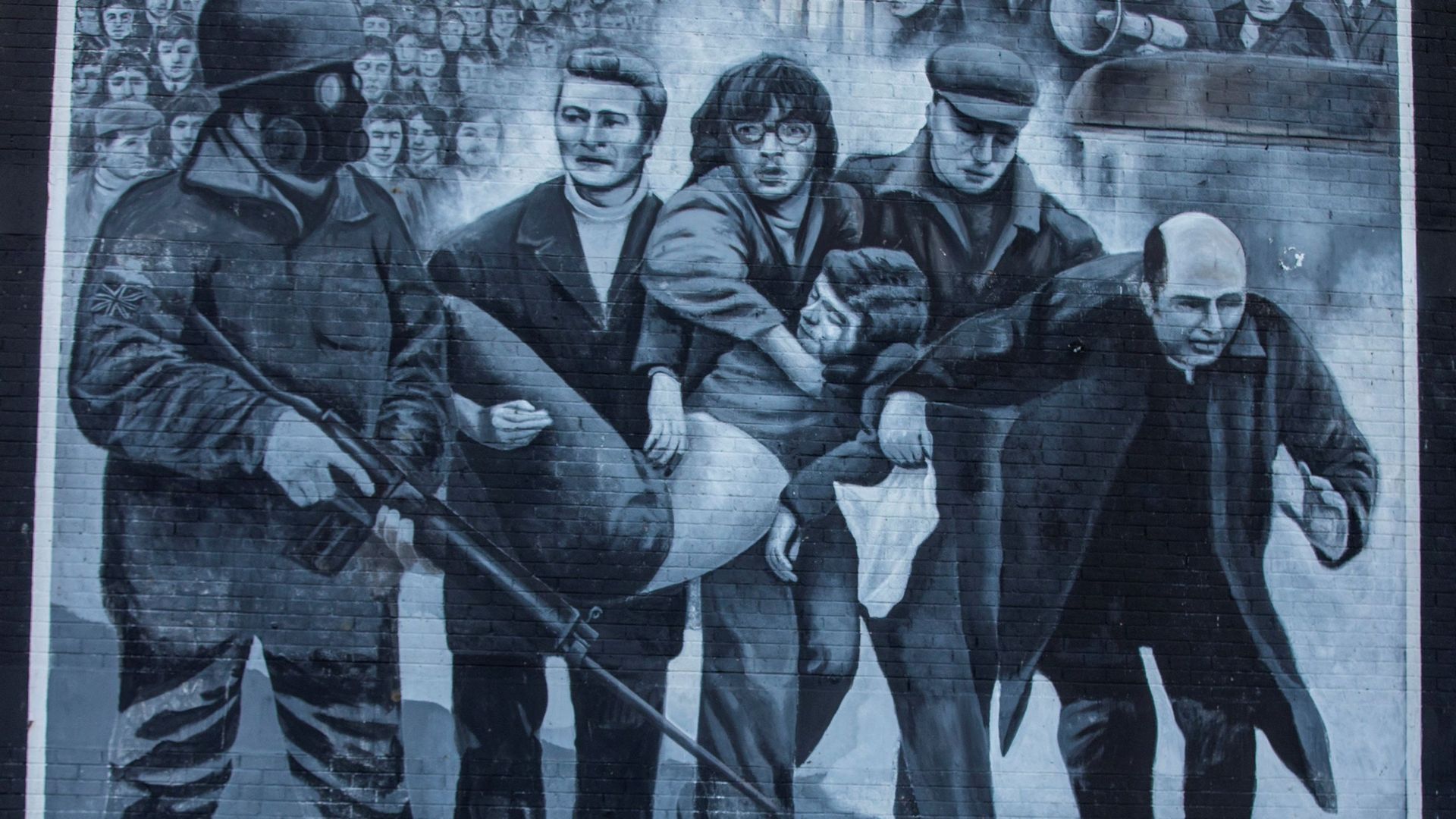 Immortalisée sur un mur du quartier de Bogside, cette scène saisie par un photographe le jour du "Bloody Sunday" montre des manifestants, dont un prêtre qui agite le mouchoir blanc, évacuer l'une des premières victimes des tirs de l'armée.