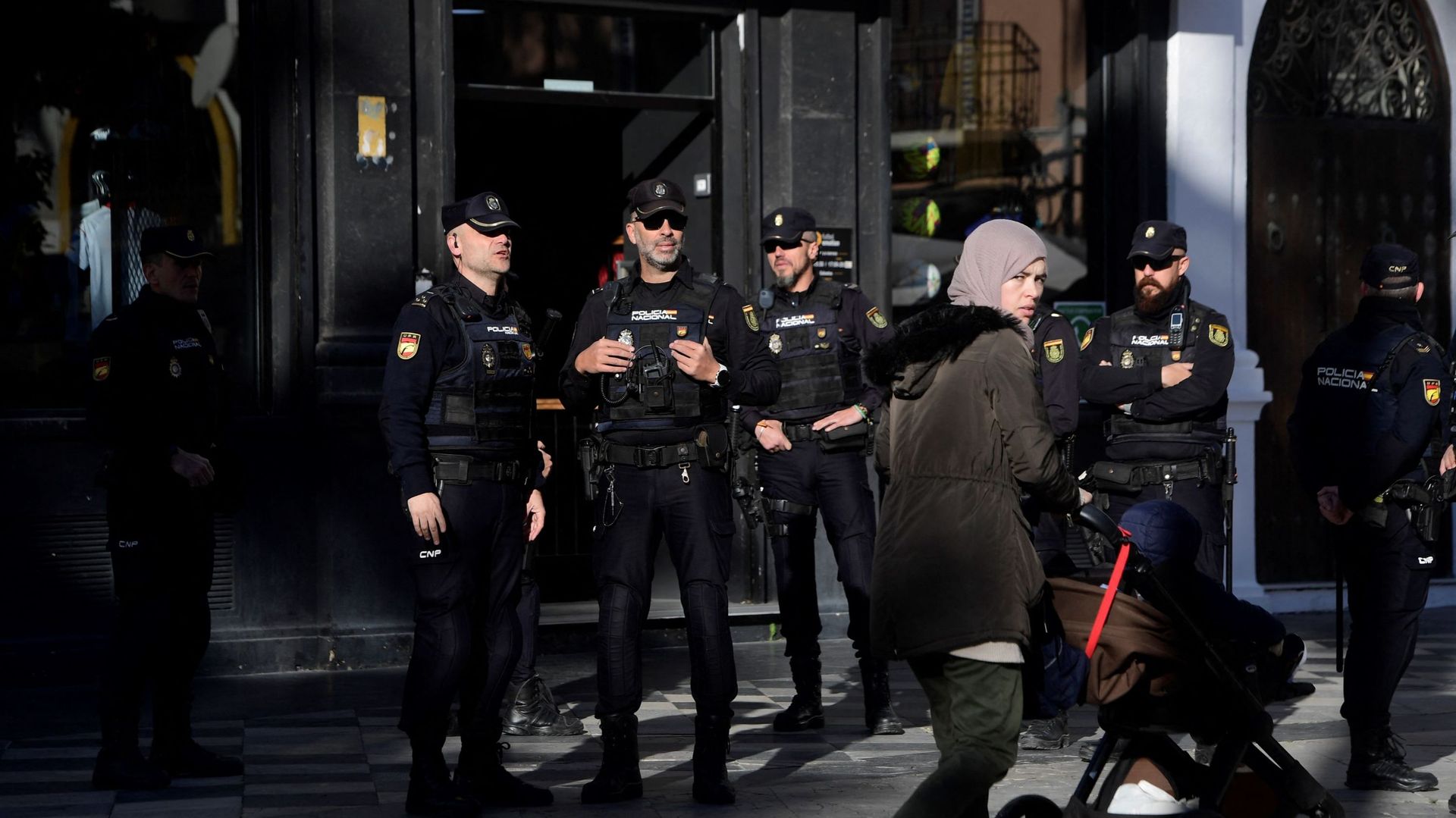Un piéton passe devant la police qui sécurise la zone près de l’église où un homme a été tué à Algeciras, dans le sud de l’Espagne, le 26 janvier 2023.