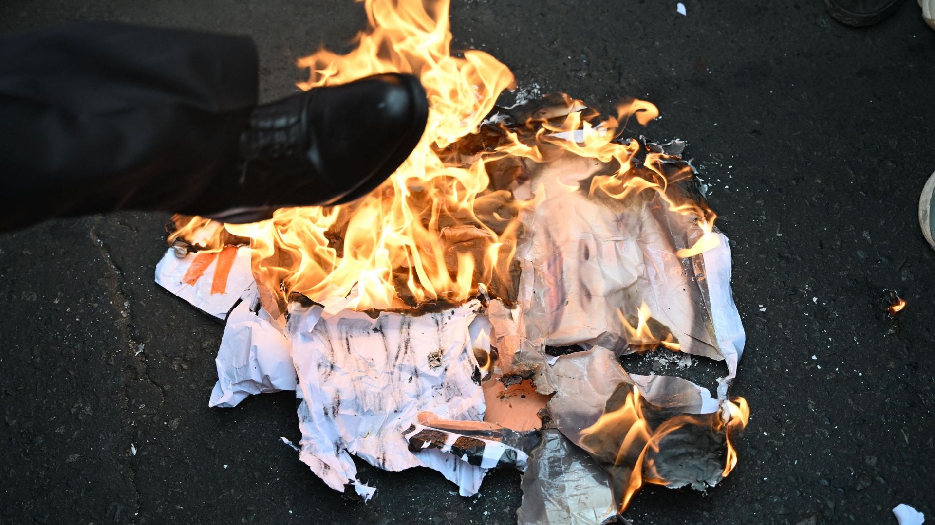 Des partisans de l'ancien président péruvien Pedro Castillo brûlent une bannière avec une photo de la nouvelle présidente péruvienne Dina Boluarte lors d'une manifestation à Lima le 9 décembre 2022.