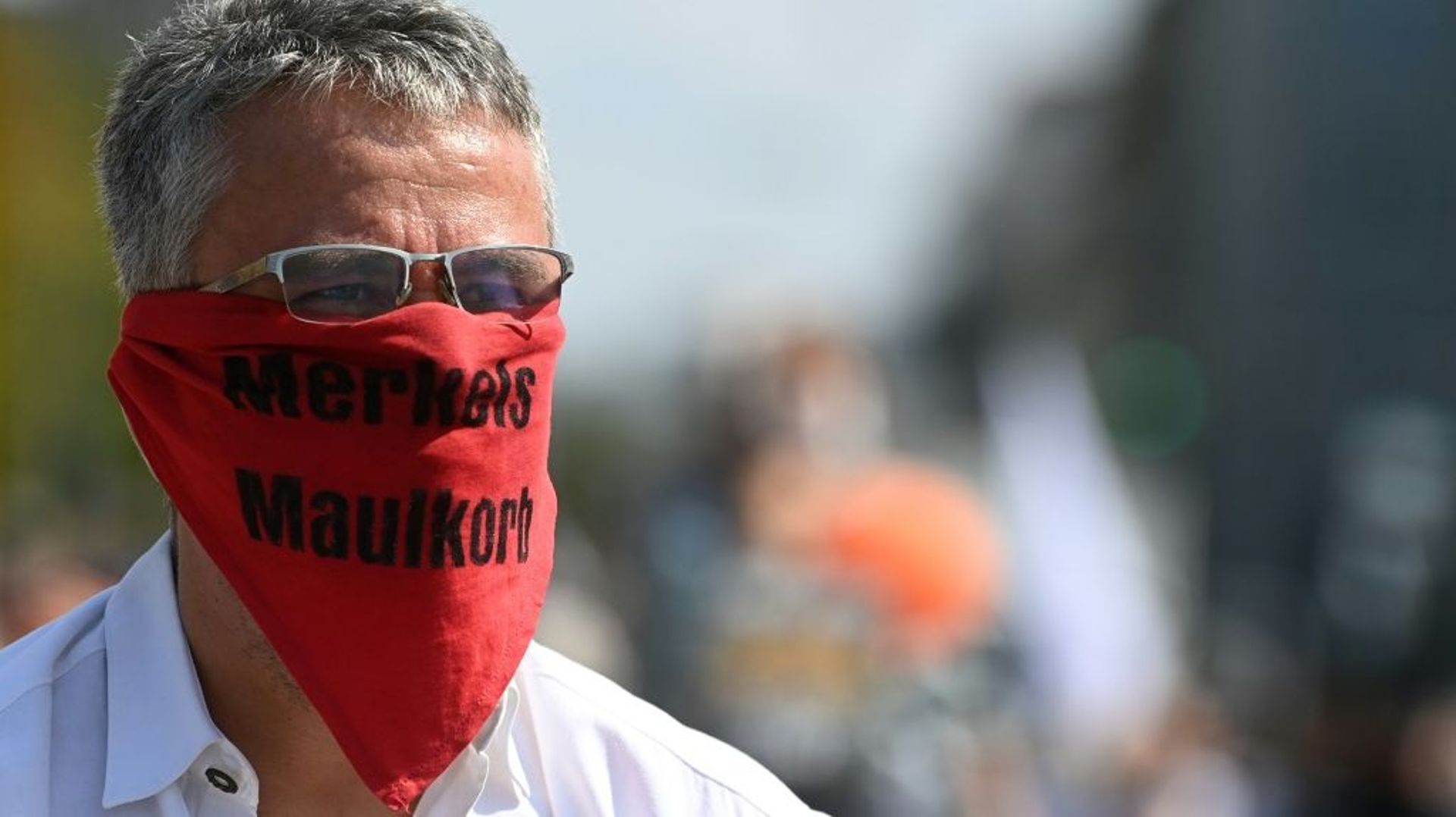 Un homme anti-restrictions Covid-19 portant un masque "la muselière de Merkel" manifeste le 12 septembre 2020 à Munich