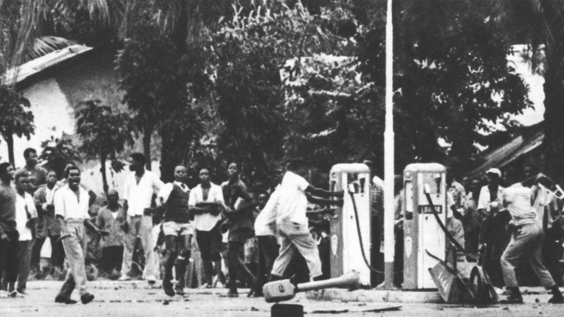Le soulèvement : la foule, déchaînée après les premiers coups de feu et les premiers pillages attaque une station d’essence sur l’avenue Prince Baudouin, qui mène à la ville blanche.