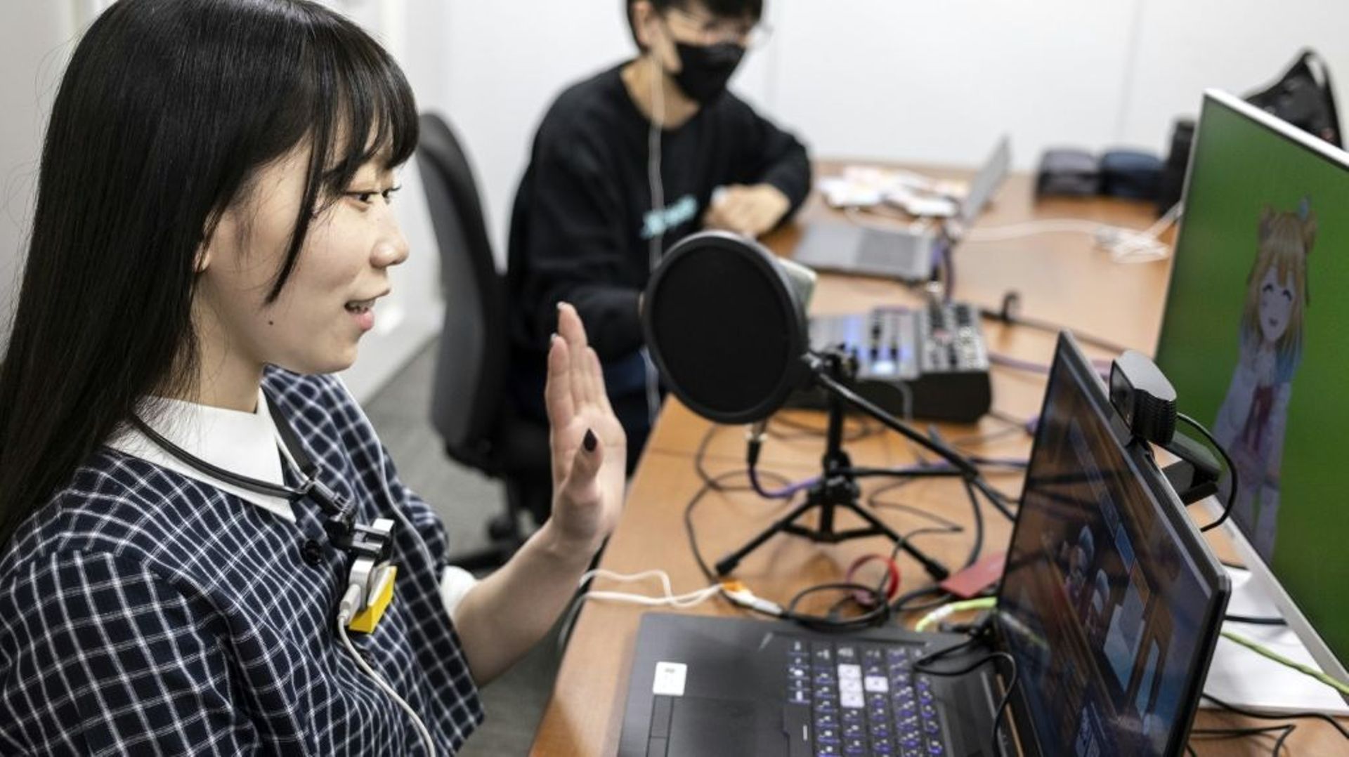 Mayu Iizuka, une YouTubeuse virtuelle , chante et anime en direct un personnage appelé Yume Kotobuki, dans un studio à Tokyo, le 7 avril 2022
