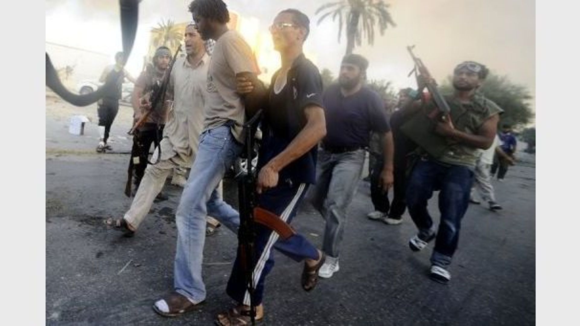 Des rebelles libyens arrêtent un combattant pro-Kadhafi, le 25 août 2011 à Abou Salim, au sud de Tripoli 