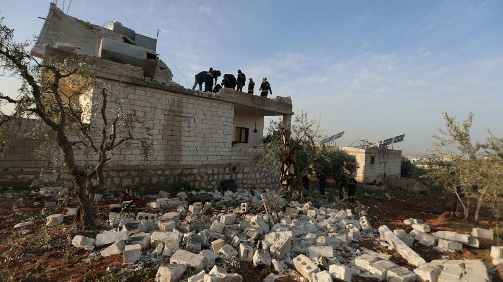 Des Syriens inspectent un bâtiment visé par une opération des forces spéciales américaines à Atmé en Syrie, le 3 février 2022