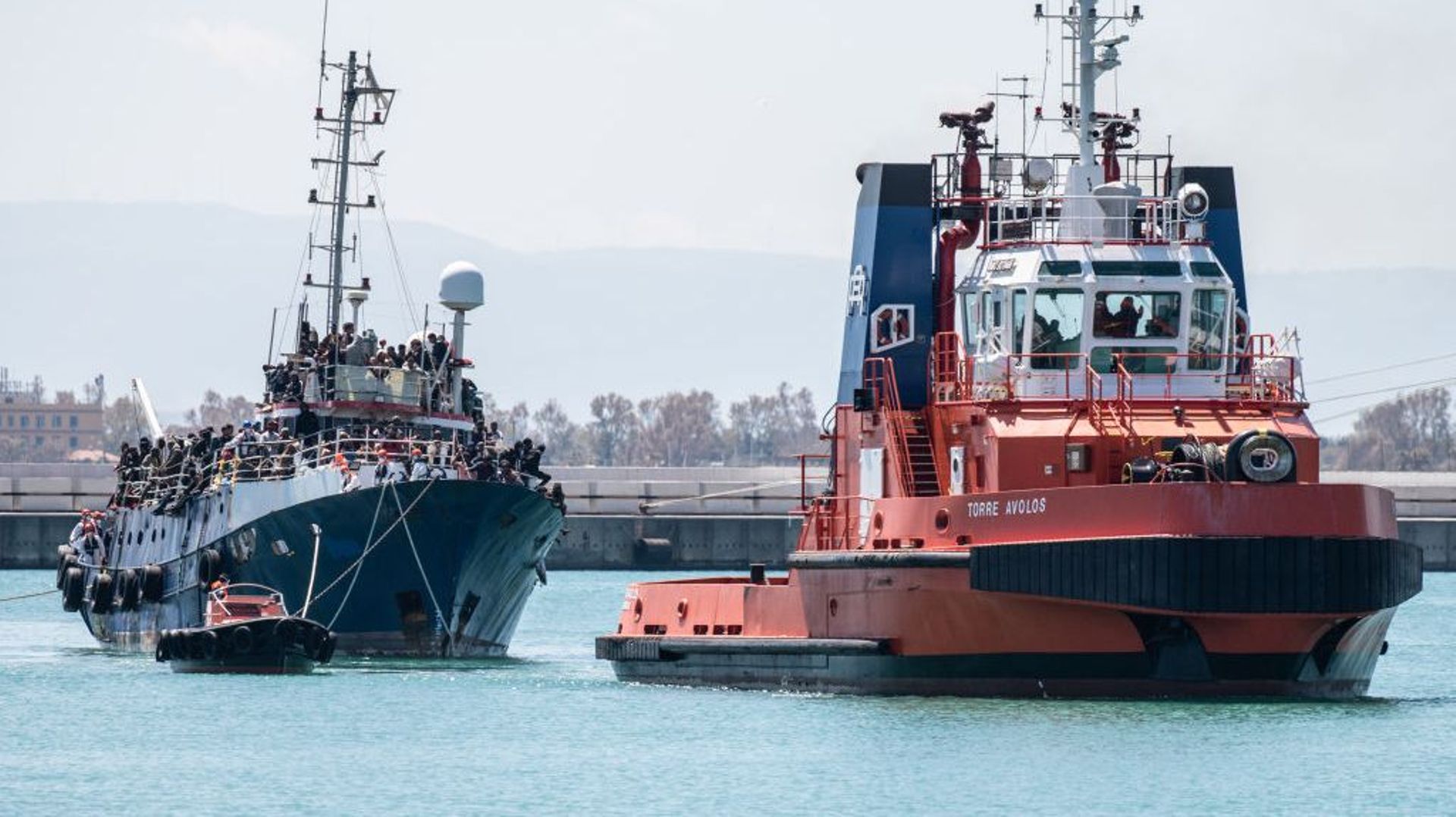 Un bateau de pêche transportant près de 700 réfugiés, remorqué par un remorqueur, entre dans le port de Catane. Le navire a été secouru par le Nave Peluso de la Garde côtière italienne le 12 avril 2023 à Catane, en Italie.