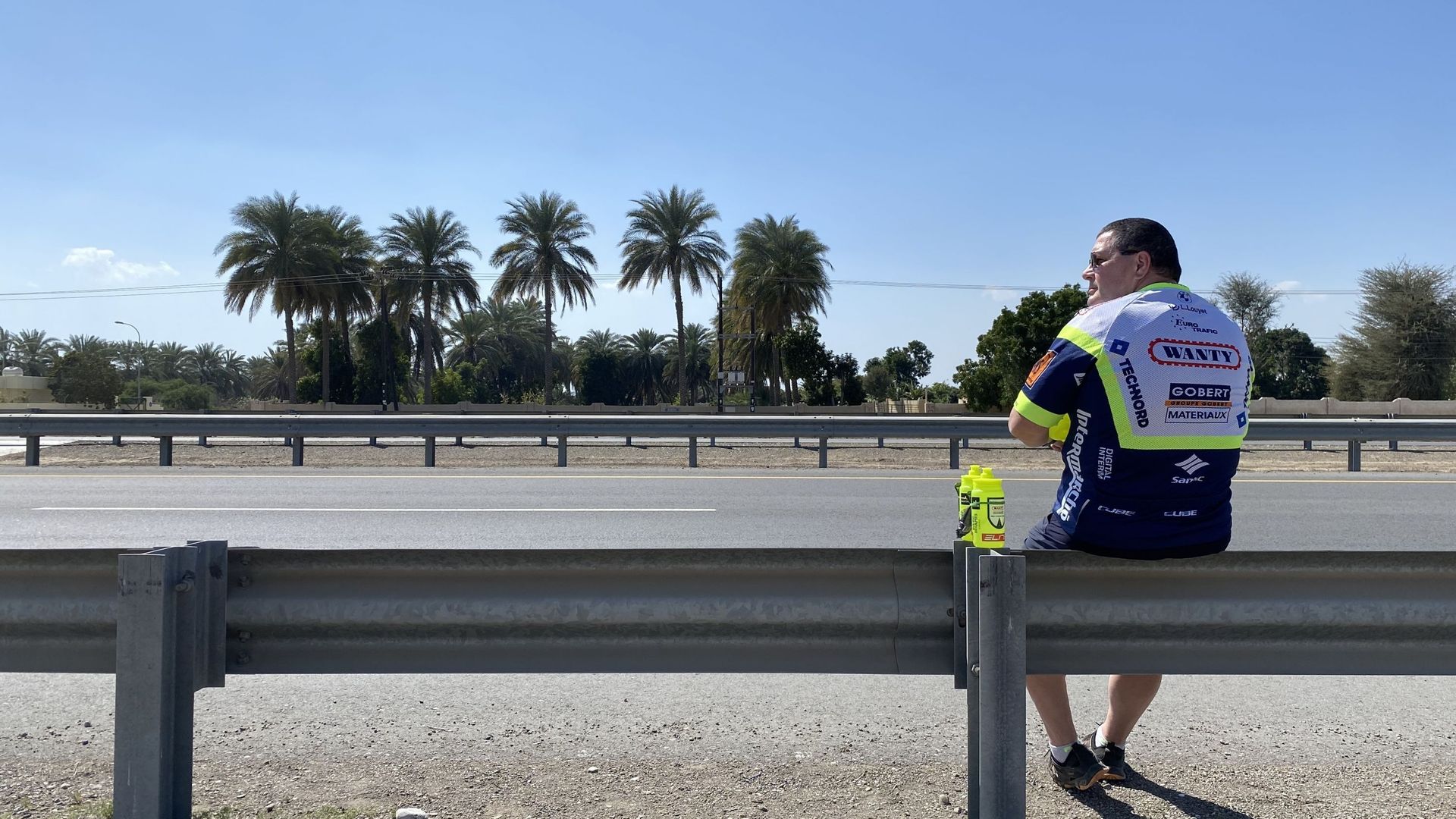Le bar est ouvert. Bruno Delbecq attend les coureurs sur le bord de la route au Tour d'Oman