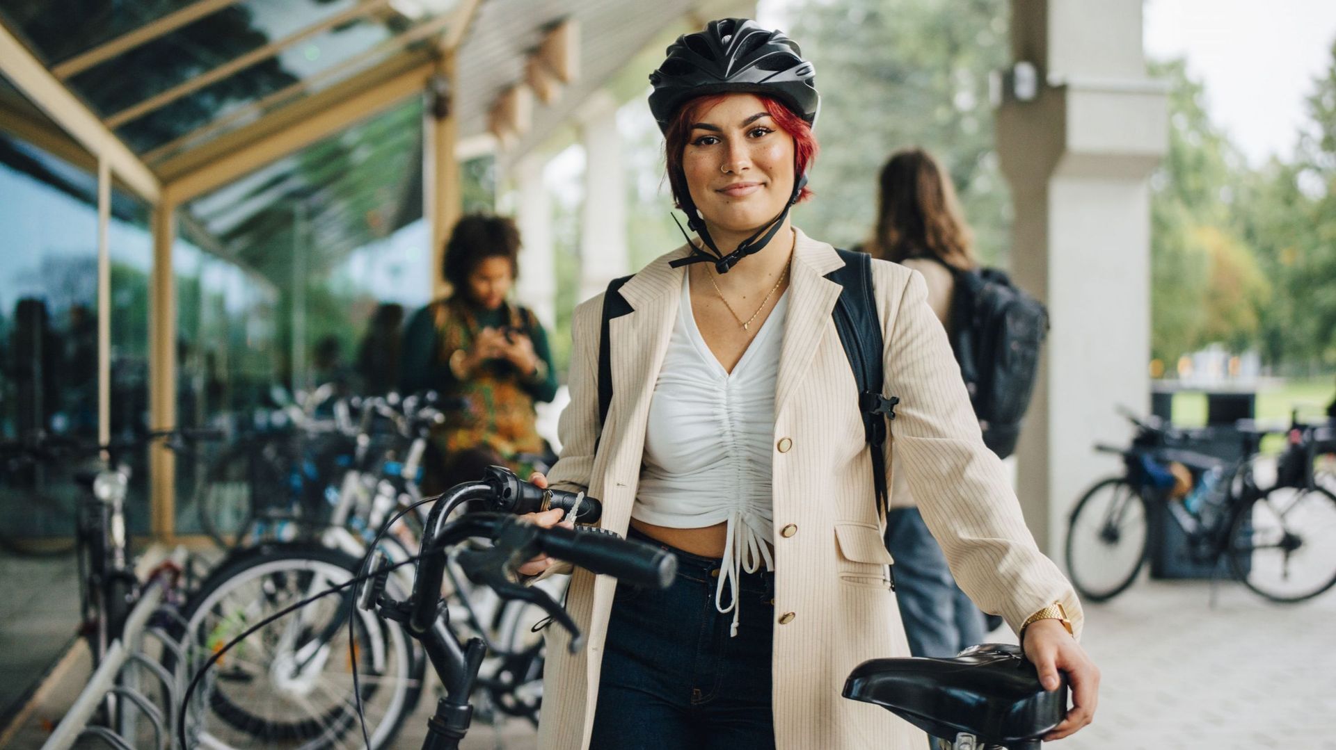 Portrait of female student with bicycle at university campus
