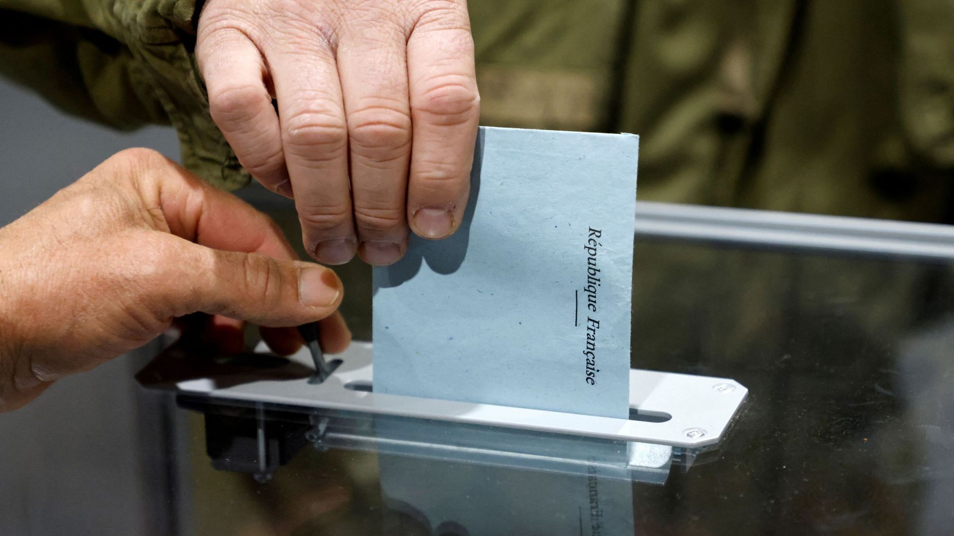 Un électeur dépose son bulletin de vote dans une urne, lors du premier tour de la présidentielle. 
