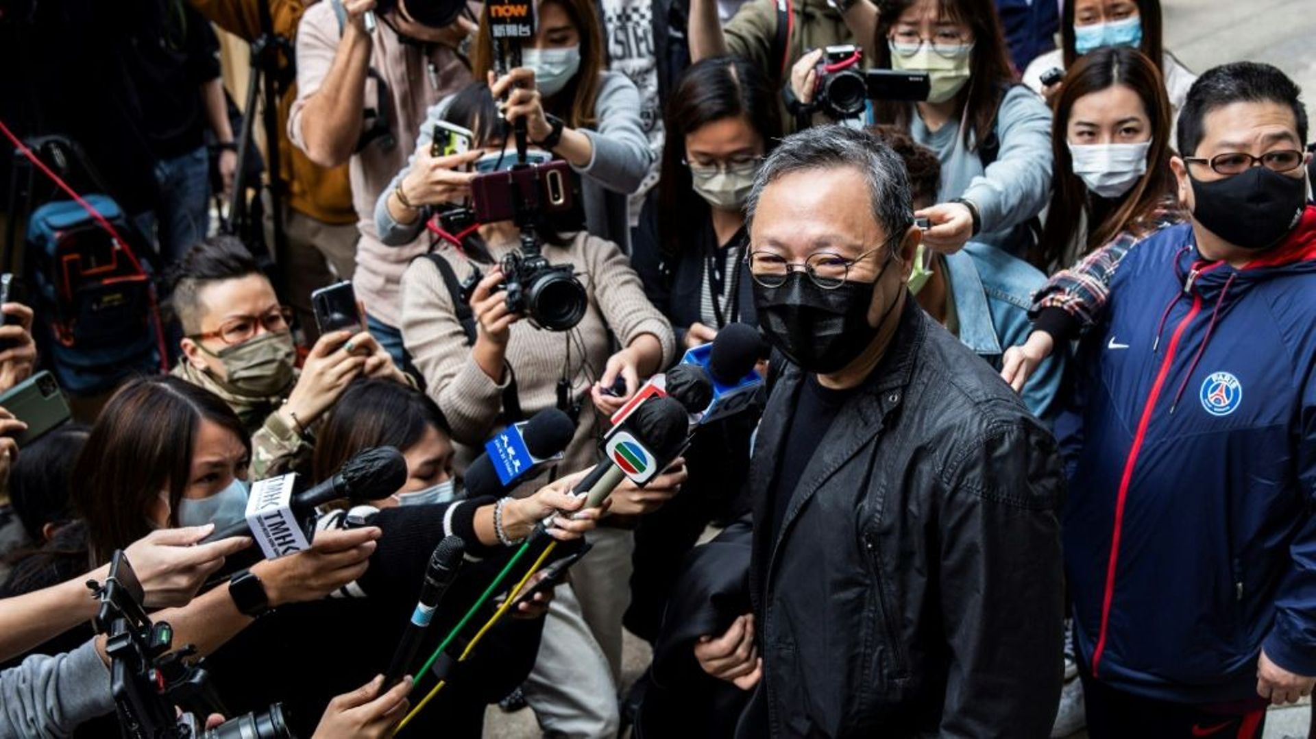 Le professeur de droit et militant pro-démocratie Benny Tai (c) fait une déclaration aux médias devant un commissariat de police où lui et 46 autres militants ont été inculpés pour "subversion", le 28 février 2021 à Hong Kong 
