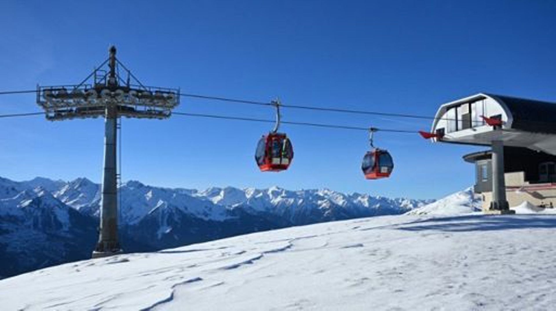 Cable car cabins transport ski tourists to and from a ski lift station in the skiing region Kitzbuehler Alpen, Hollersbach, Austrian province of Salzburg, on November 27, 2022.   One of Austria's top ski resorts was making as much artificial snow as possi